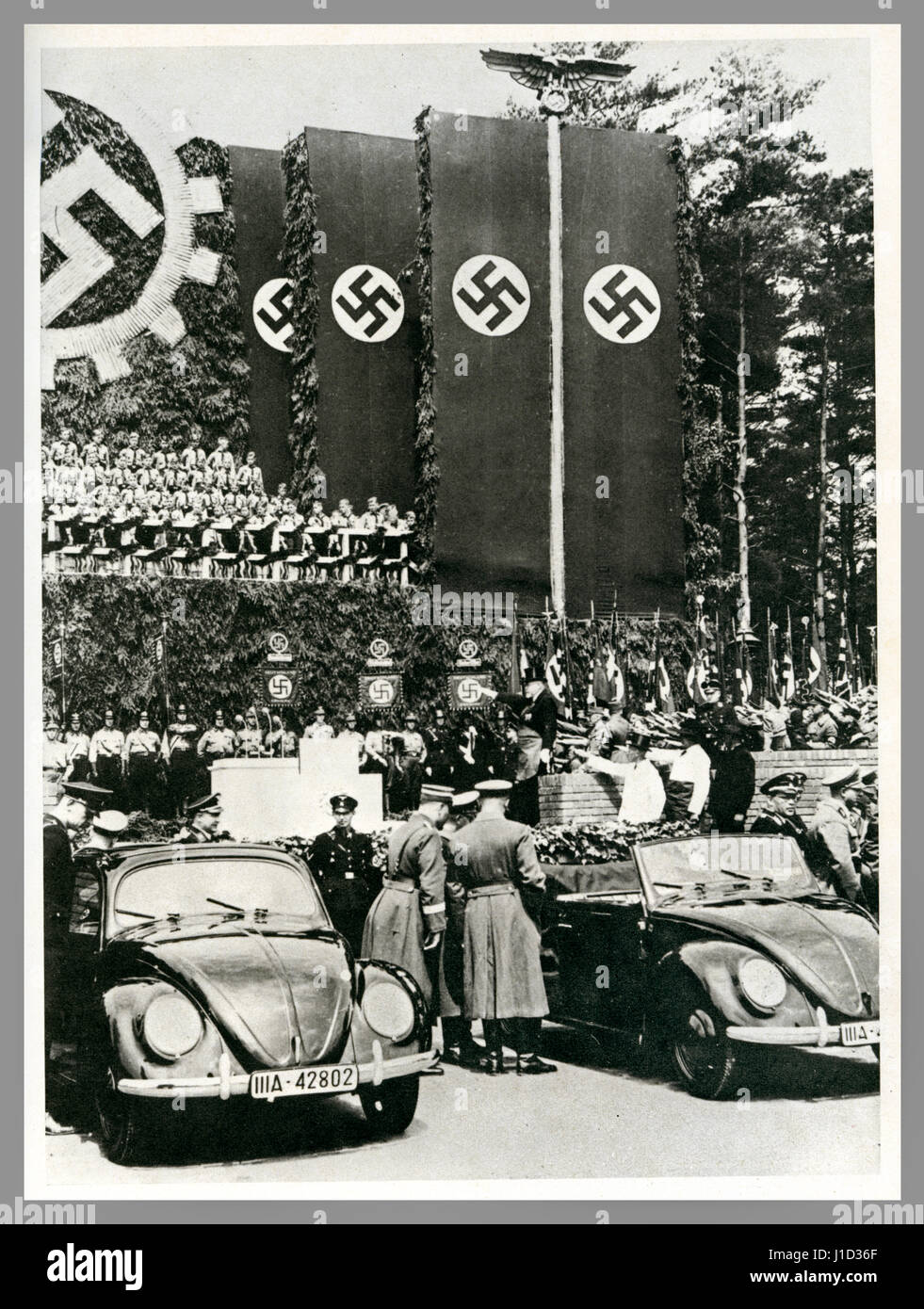 KDF -Wagen Volkswagen lanzamiento Alemania propaganda imagen 26 de mayo de 1938 fundación de piedra de colocación ceremonia en la fábrica de Wolfsleben Wolfsburg Volkswagen con nuevos coches KdF -Wagen (fuerza a través de la alegría) en exhibición bajo las banderas nazis de Swastika Foto de stock