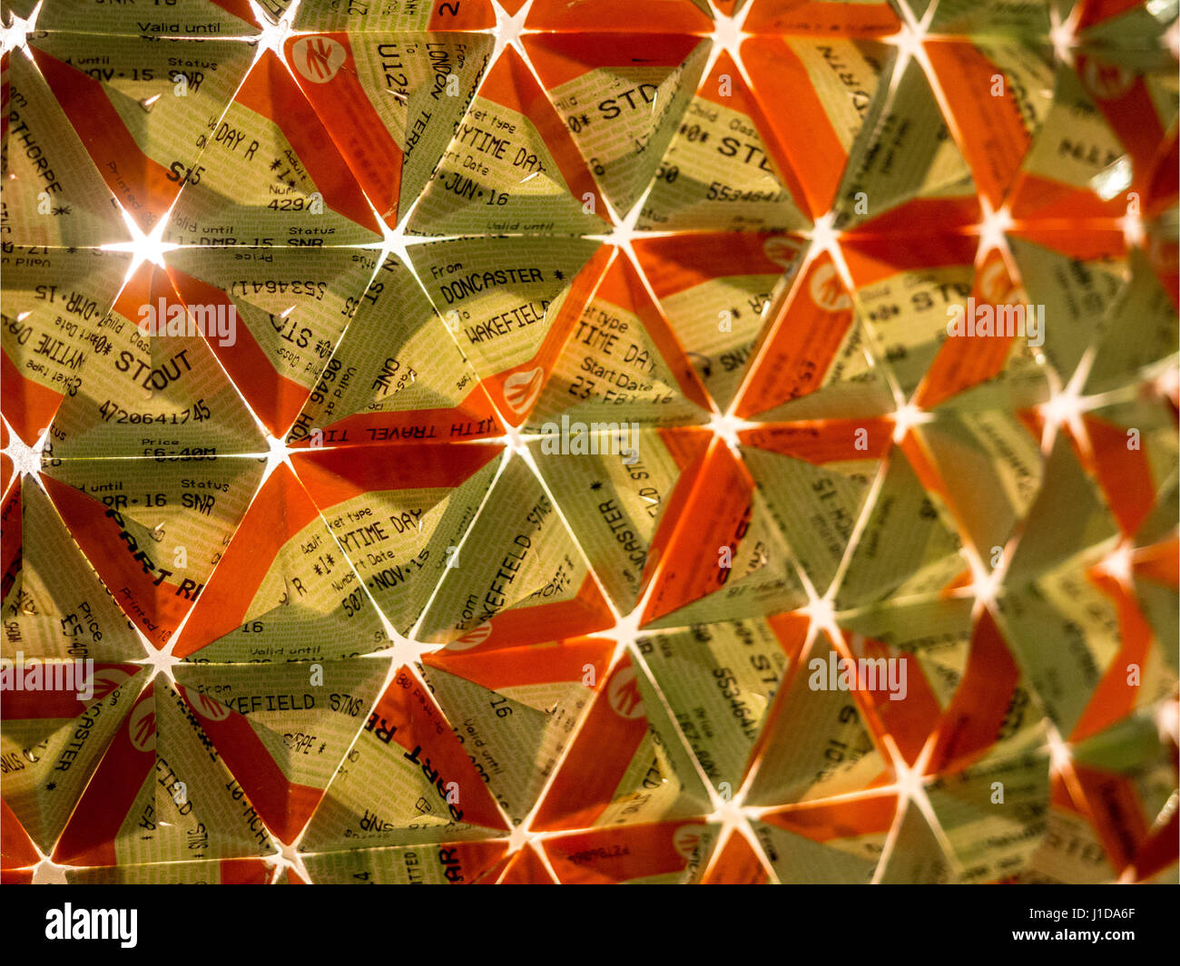 Cerca de boletos de tren plegadas en un modelo triangular con luz brillando a través de detrás Foto de stock