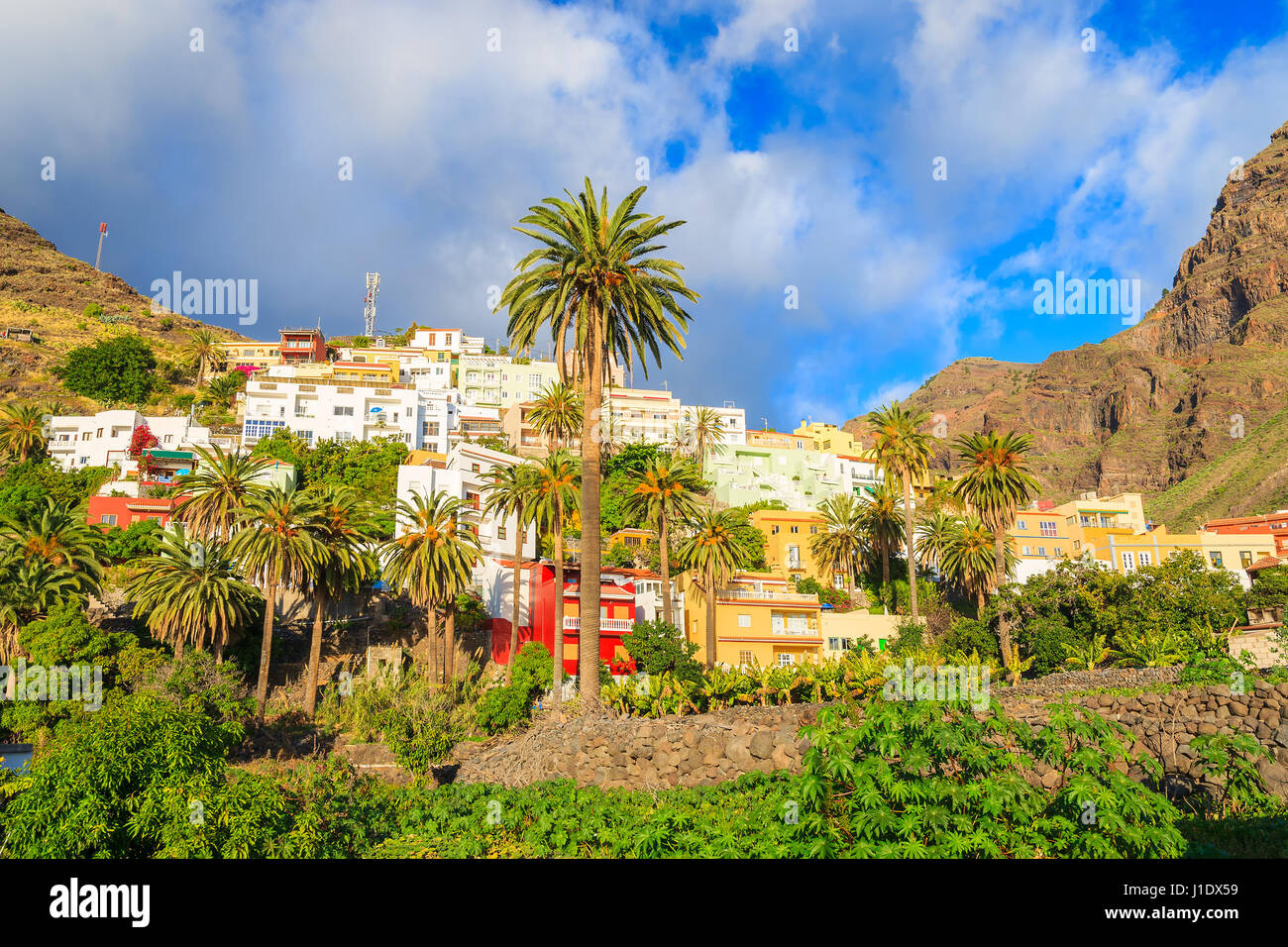 Coloridas casas de gran valle poblado en el paisaje tropical de la montaña de la isla de La Gomera, España Foto de stock