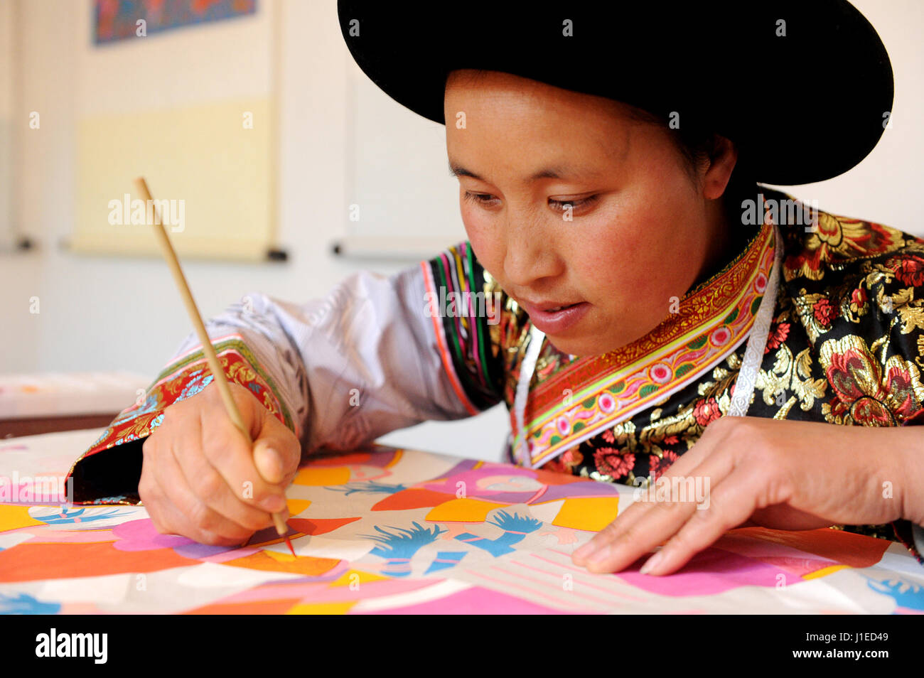 (170421) --(GUIZHOU SHUICHENG), 21 de abril de 2017 (Xinhua) -- Aldeano Yang Mingying dibuja imágenes en aldea de Houerguan Doujing Township en el condado Shuicheng, en el suroeste de la provincia de Guizhou en China, 21 de abril de 2017. Los aldeanos de etnia Miao en aldea Hoerguan creado 'Shuicheng aldeano pintura' que compromete los méritos de batik, bordado y punto de cruz. (Xinhua/Tao Liang) (zkr) Foto de stock