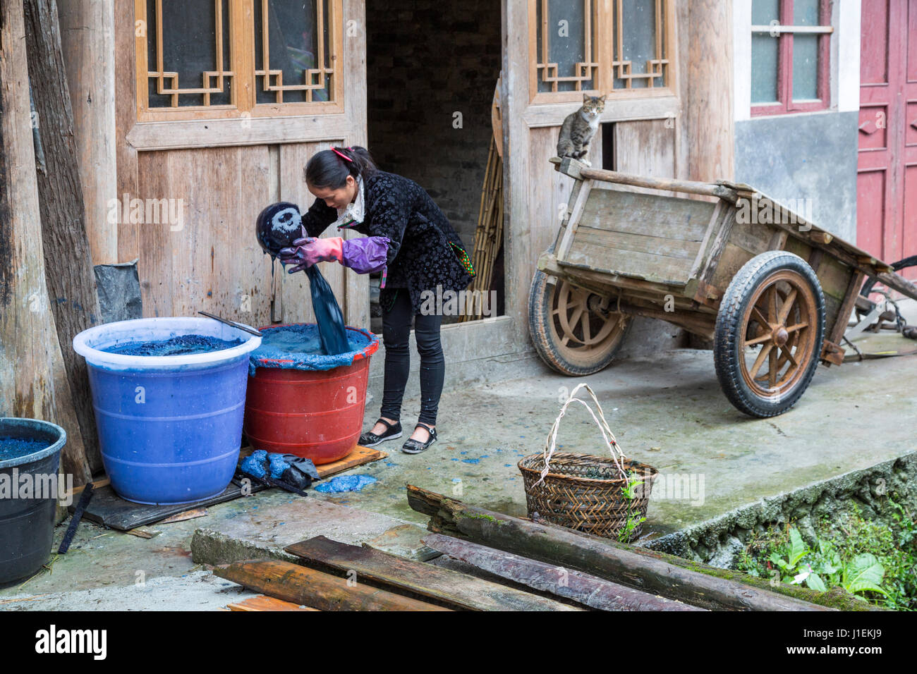 Huanggang, Guizhou, China. Un pueblo étnico dong. Mujer mezcla colorante índigo. Foto de stock