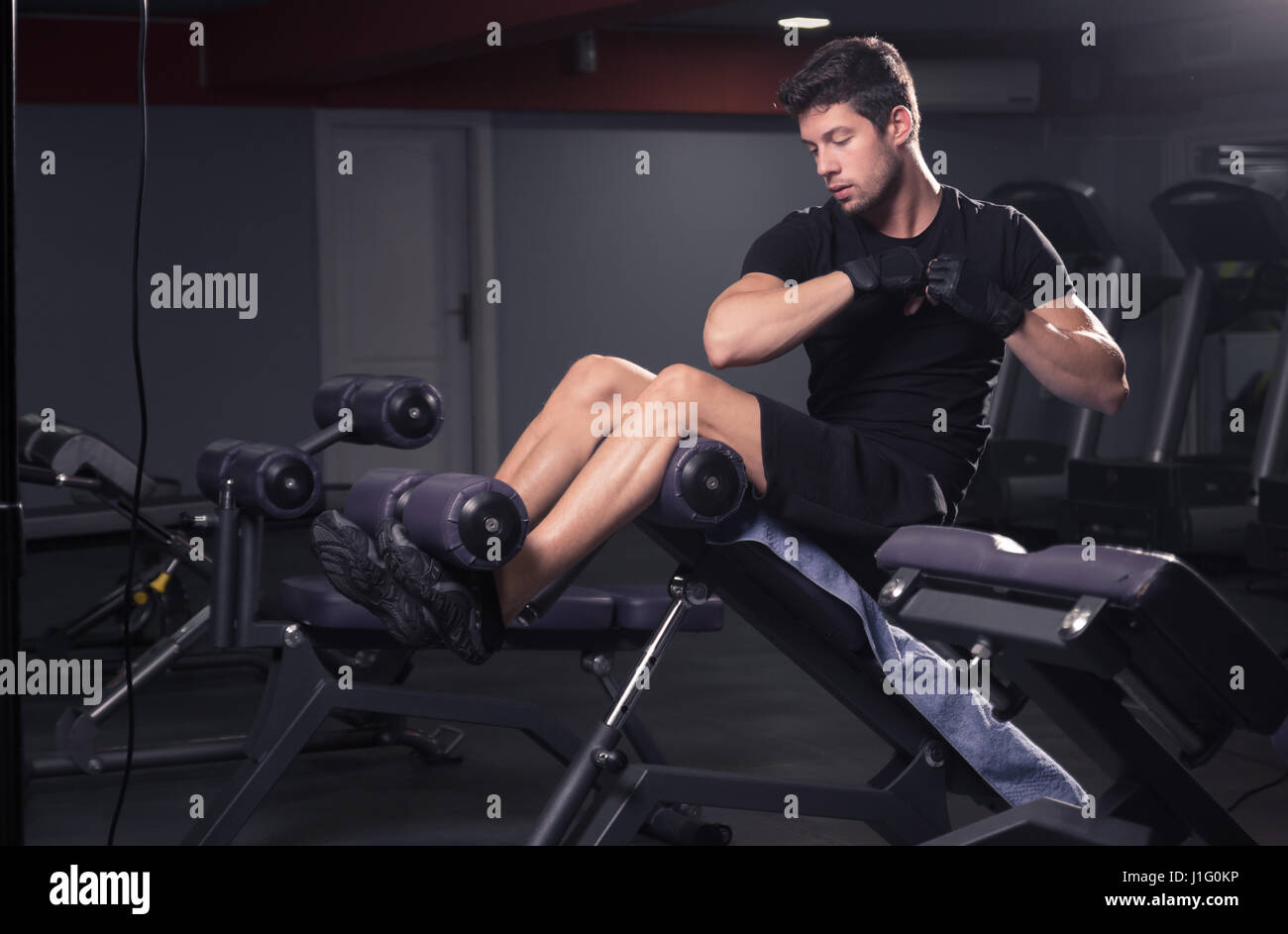 El hombre ejercicio lado abs core, banqueta gimnasio en interiores  Fotografía de stock - Alamy