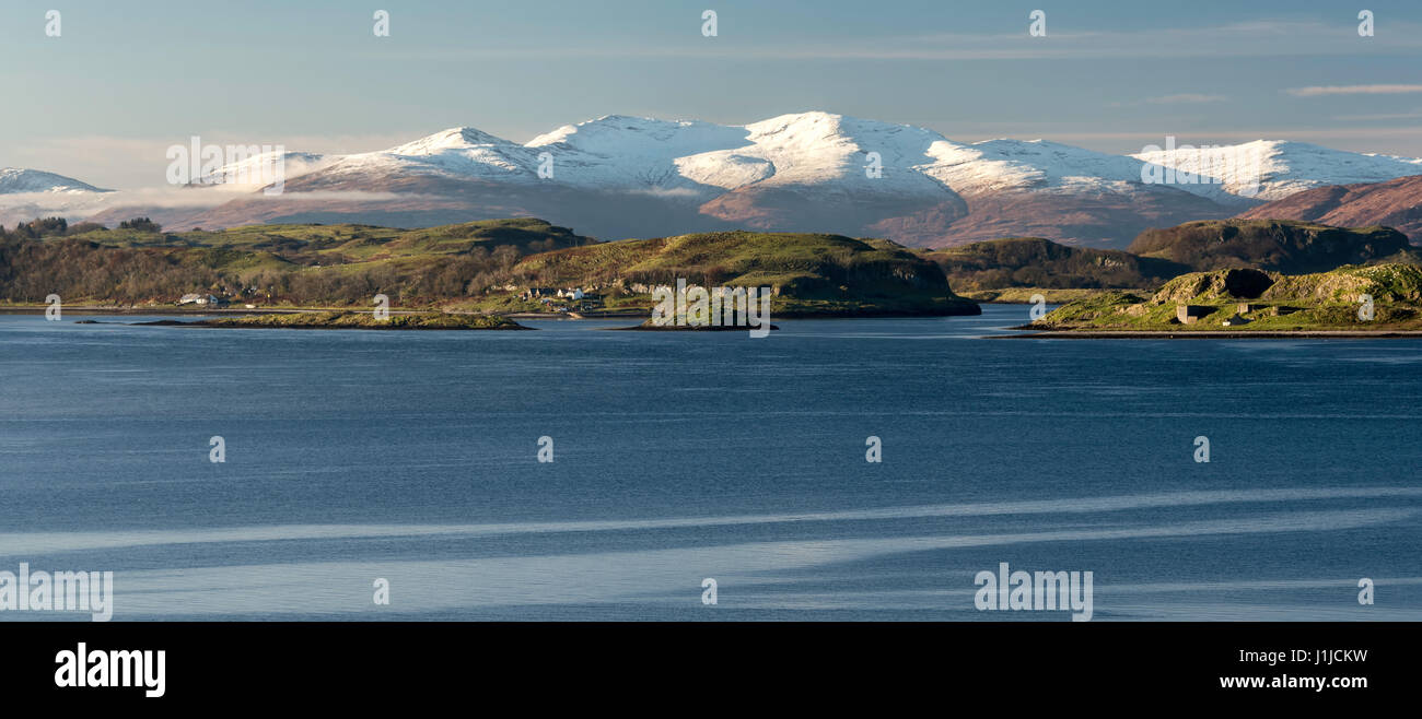 Loch Linnhe con isla Lismore y las colinas cubiertas de nieve en el fondo de Kingairloch, Glencoe, Escocia Foto de stock
