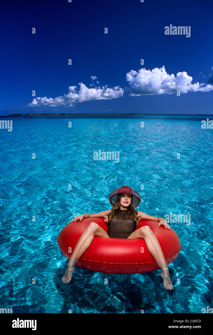 Mujer joven flotando en un tubo interior Foto de stock