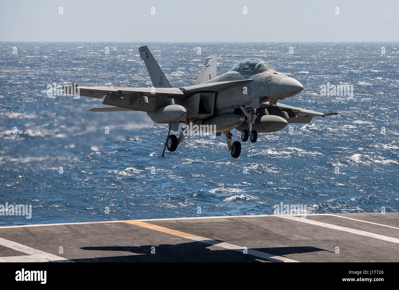 La Marina estadounidense F/A-18F Super Hornet aviones de combate enfoques para aterrizar en la cubierta de vuelo de la clase Nimitz portaaviones USS George H.W. Bush durante operaciones contra el Estado Islámico en funcionamiento inherente resolver el 4 de abril de 2017 en el Golfo Arábigo. Foto de stock