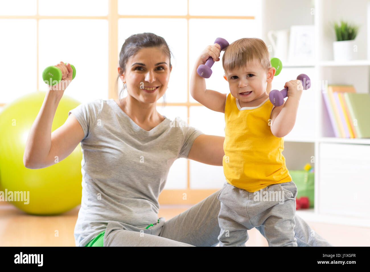 Lindo madre con chico haciendo gimnasia y ejercicios físicos Foto de stock