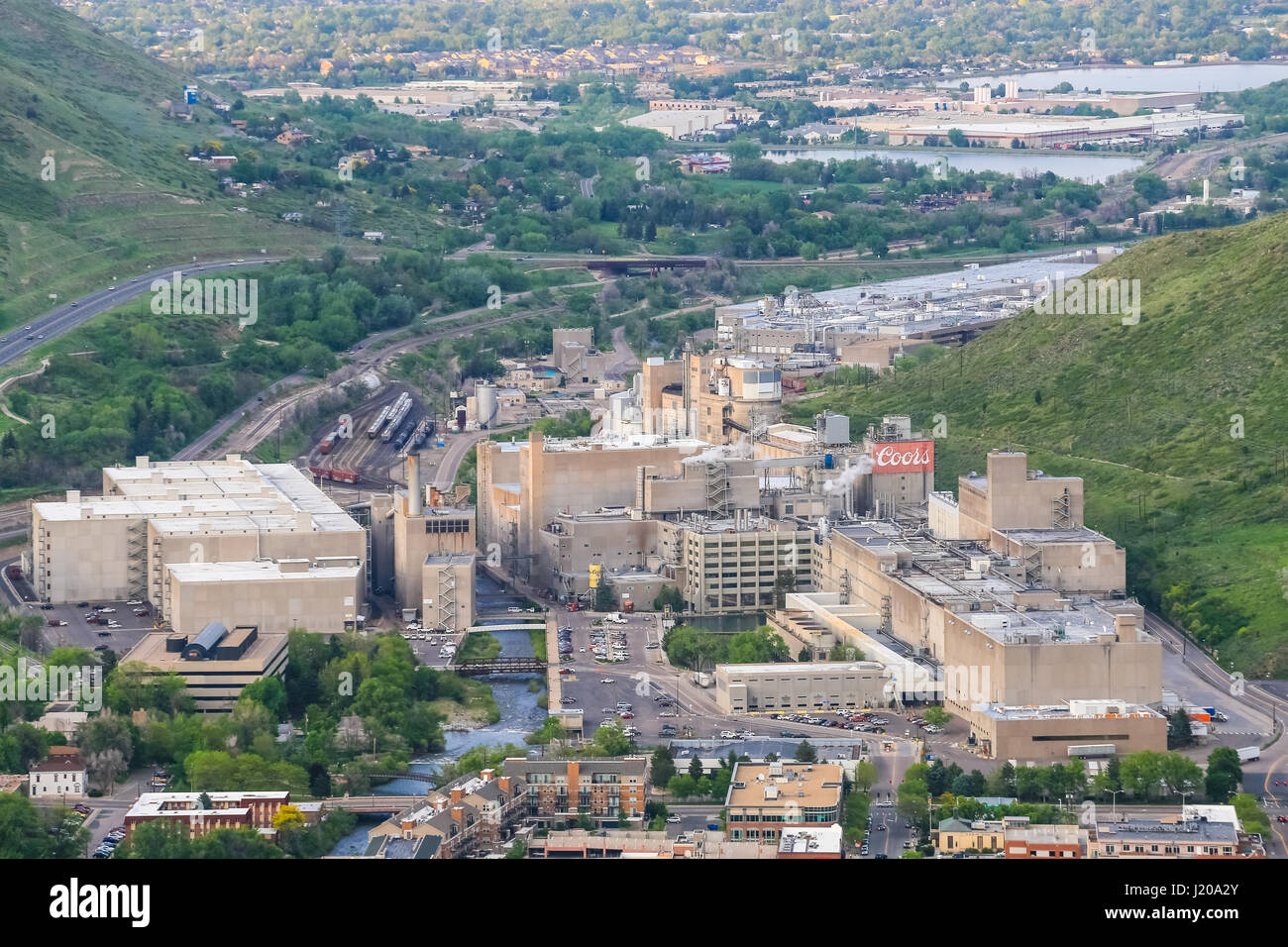 Golden, USA - Mayo 26, 2016: Vistas de Coors Brewery en Colorado con varios edificios, carreteras y pistas con coches y trenes y un riachuelo funcio Foto de stock