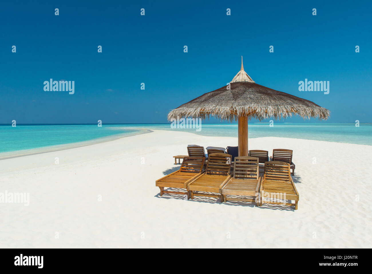 Playa tropical en las Maldivas con sillas de lona y sombrillas Fotografía  de stock - Alamy