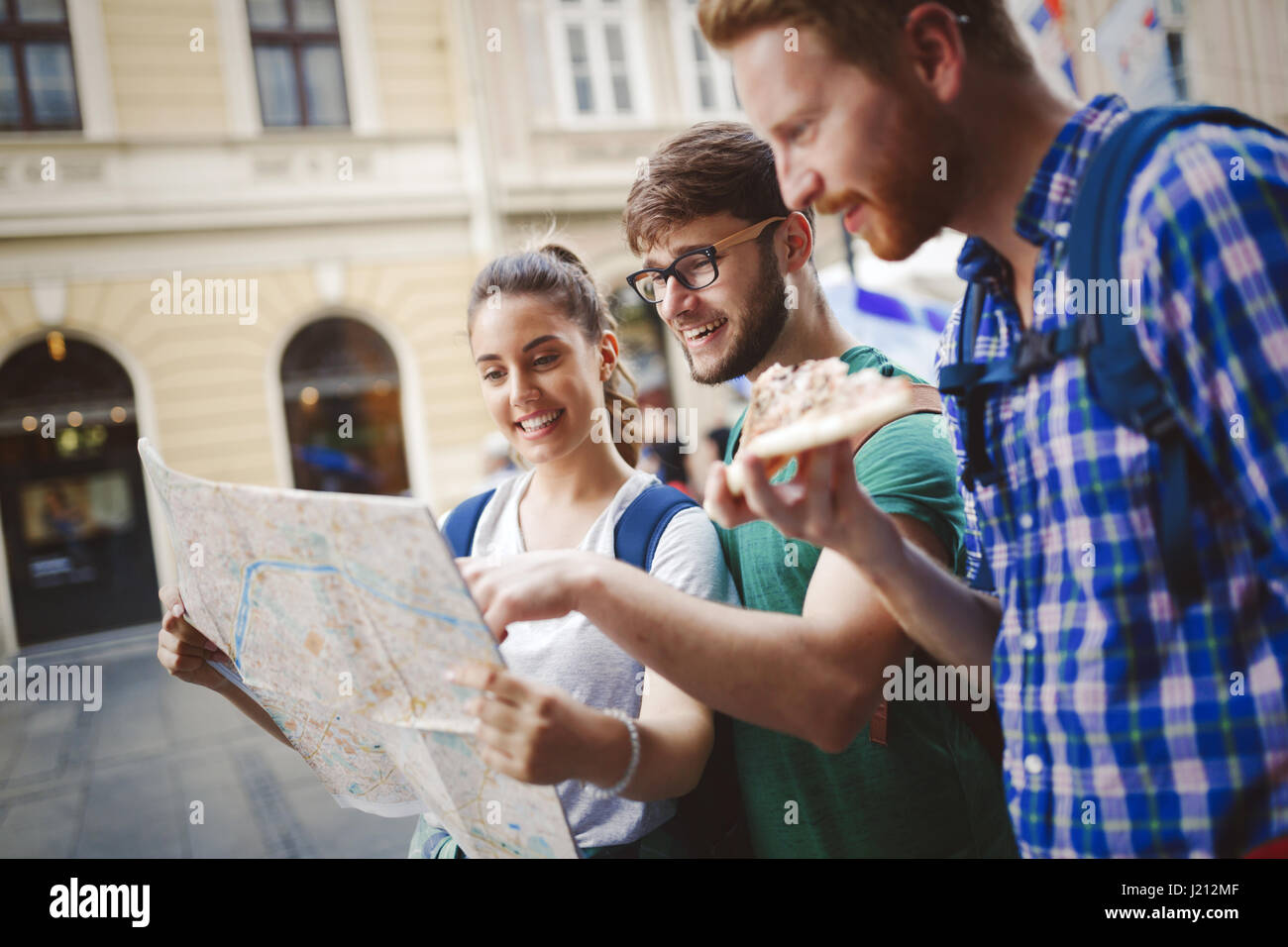 Jóvenes turistas feliz celebración mapa excursiones en la ciudad Foto de stock