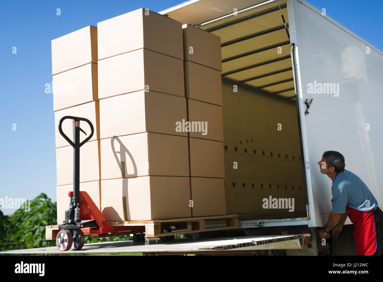La carga y el transporte de mercancías por camión que transportaba cajas  Fotografía de stock - Alamy
