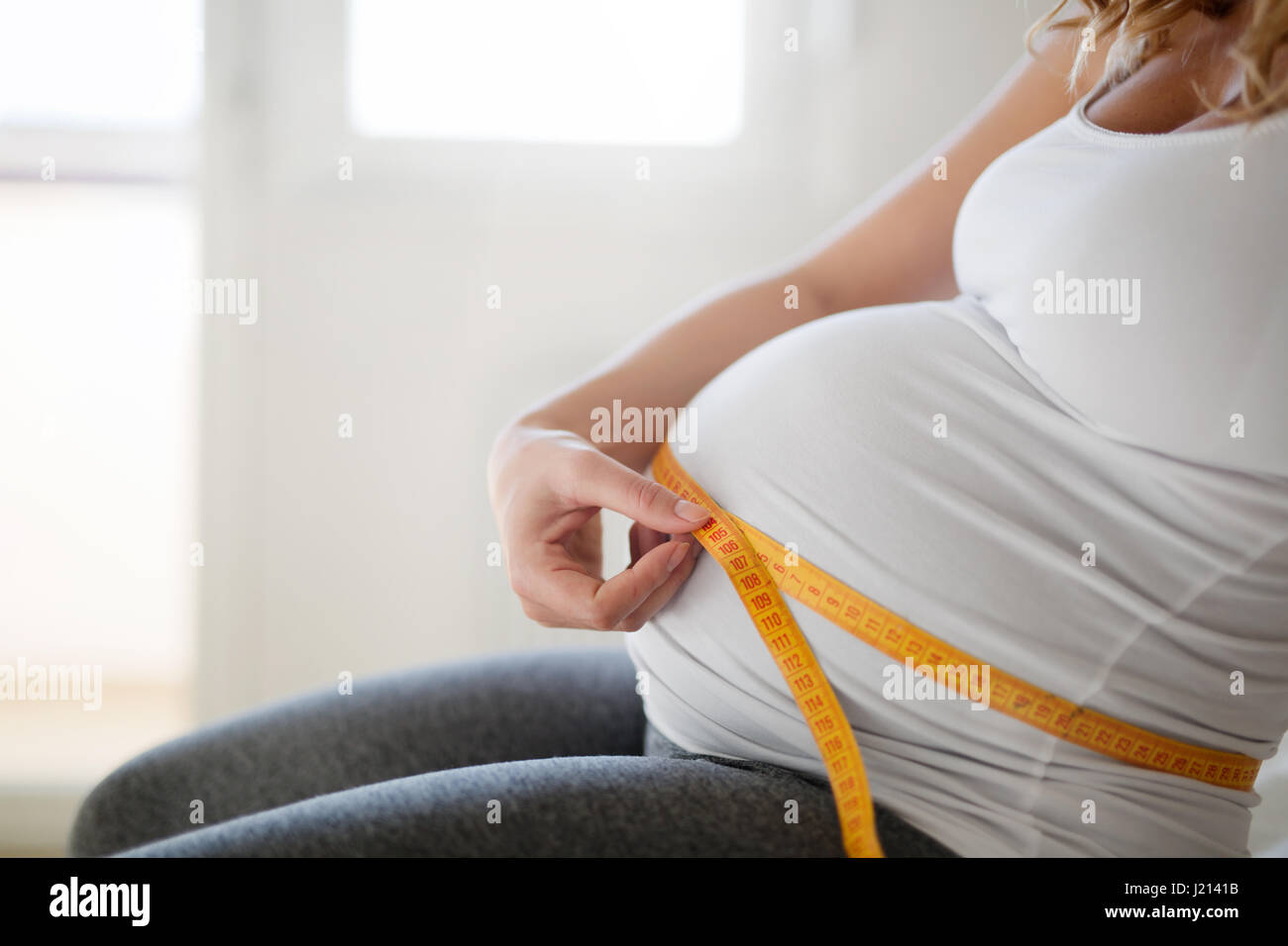 La Mujer Embarazada Mide La Cinta Del Centímetro De Circunferencia Abdominal,  Cerca, Aislado En Fondo Blanco Fotos, retratos, imágenes y fotografía de  archivo libres de derecho. Image 63584907