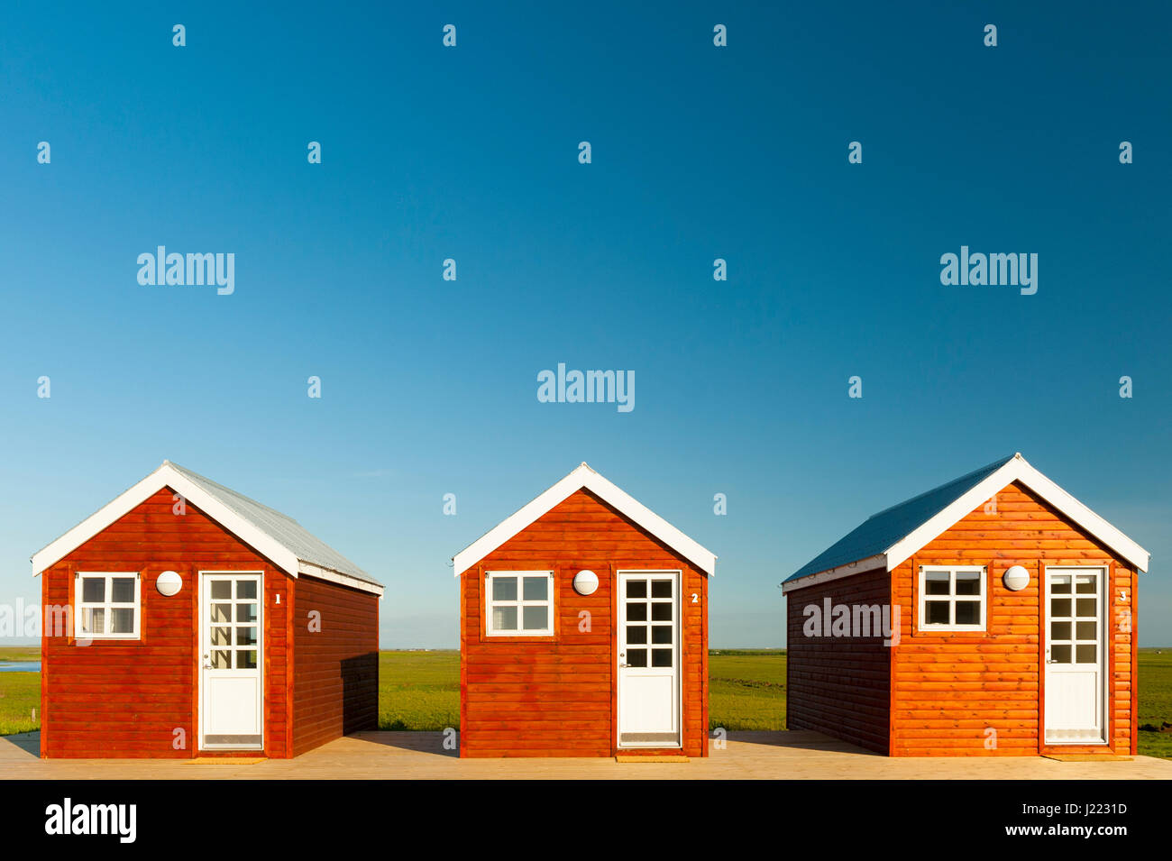 Tres cabañas de madera, día soleado, alojamiento, vivienda, hipotecas, concepto, alojamiento, viajes, Islandia. Foto de stock