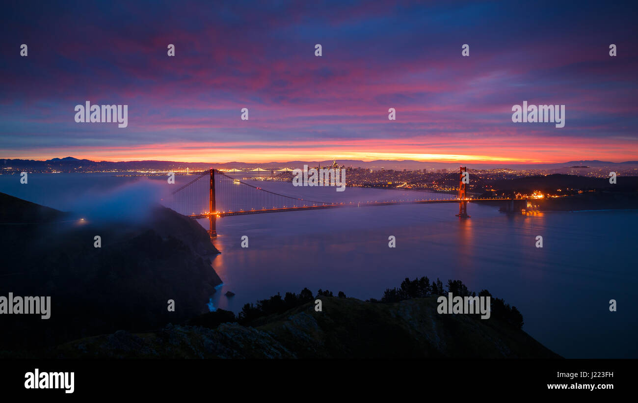 El puente Golden Gate y la ciudad de san Francisco al amanecer con dramáticas nubes Foto de stock