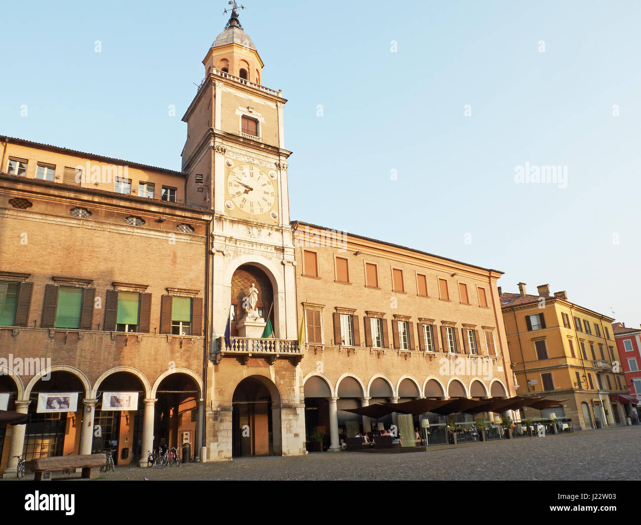 Torre delle Orologio, la torre del reloj, del Palazzo Comunale, ayuntamiento de la ciudad, en la Piazza Grande de Módena al atardecer. Emilia-romaña. Italia Foto de stock