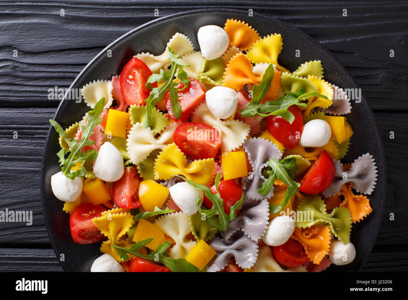 Comida italiana: Pasta Farfalle con verduras y mozzarella de cerca en una placa vista desde arriba de la horizontal. Foto de stock