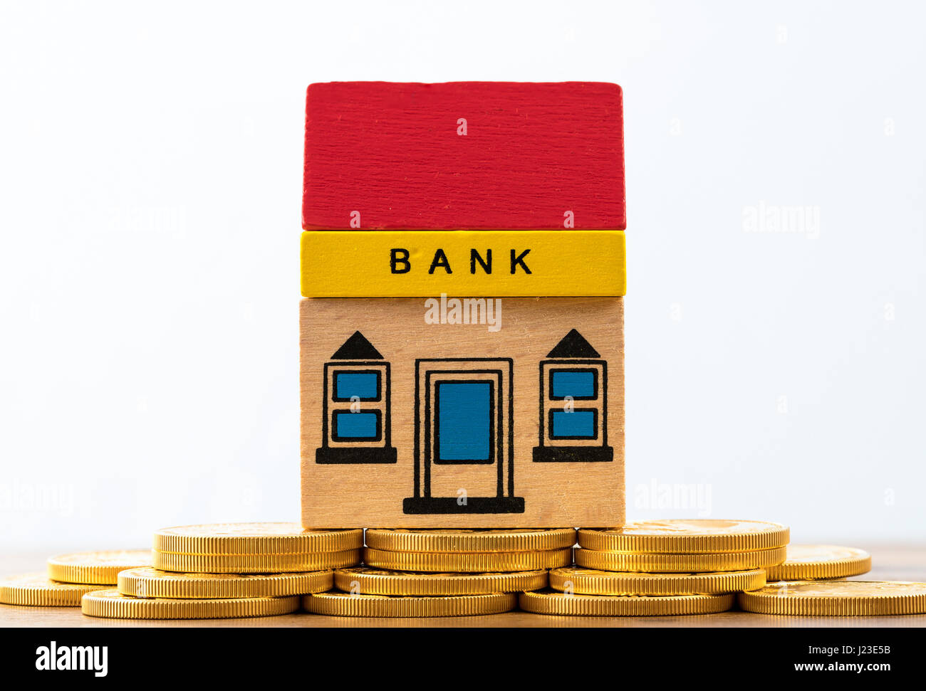 Edificio del Banco de juguete en monedas de oro - concepto de banca Foto de stock