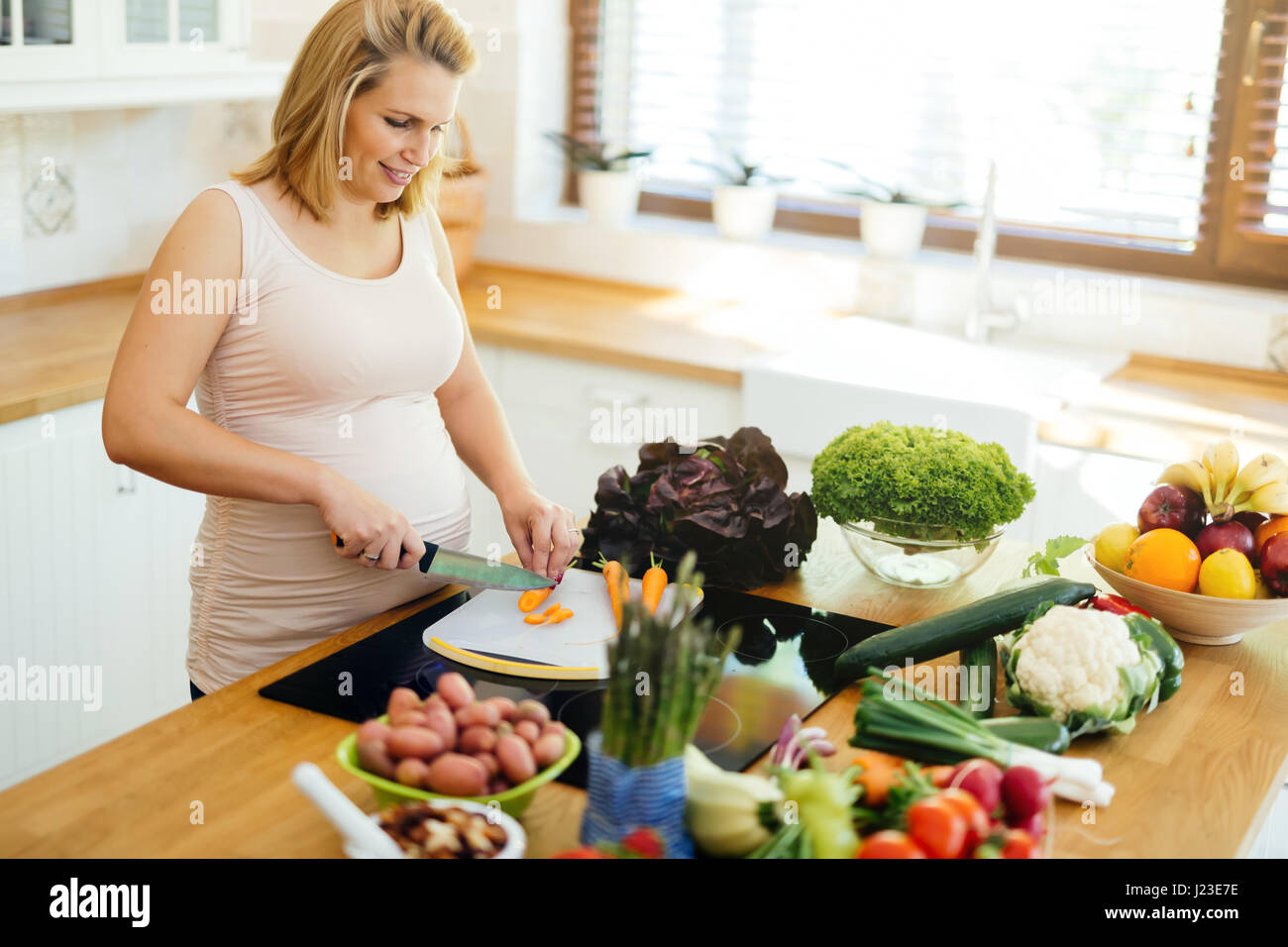 Mujer embarazada comer sano preparando comida a base de ingredientes frescos Foto de stock