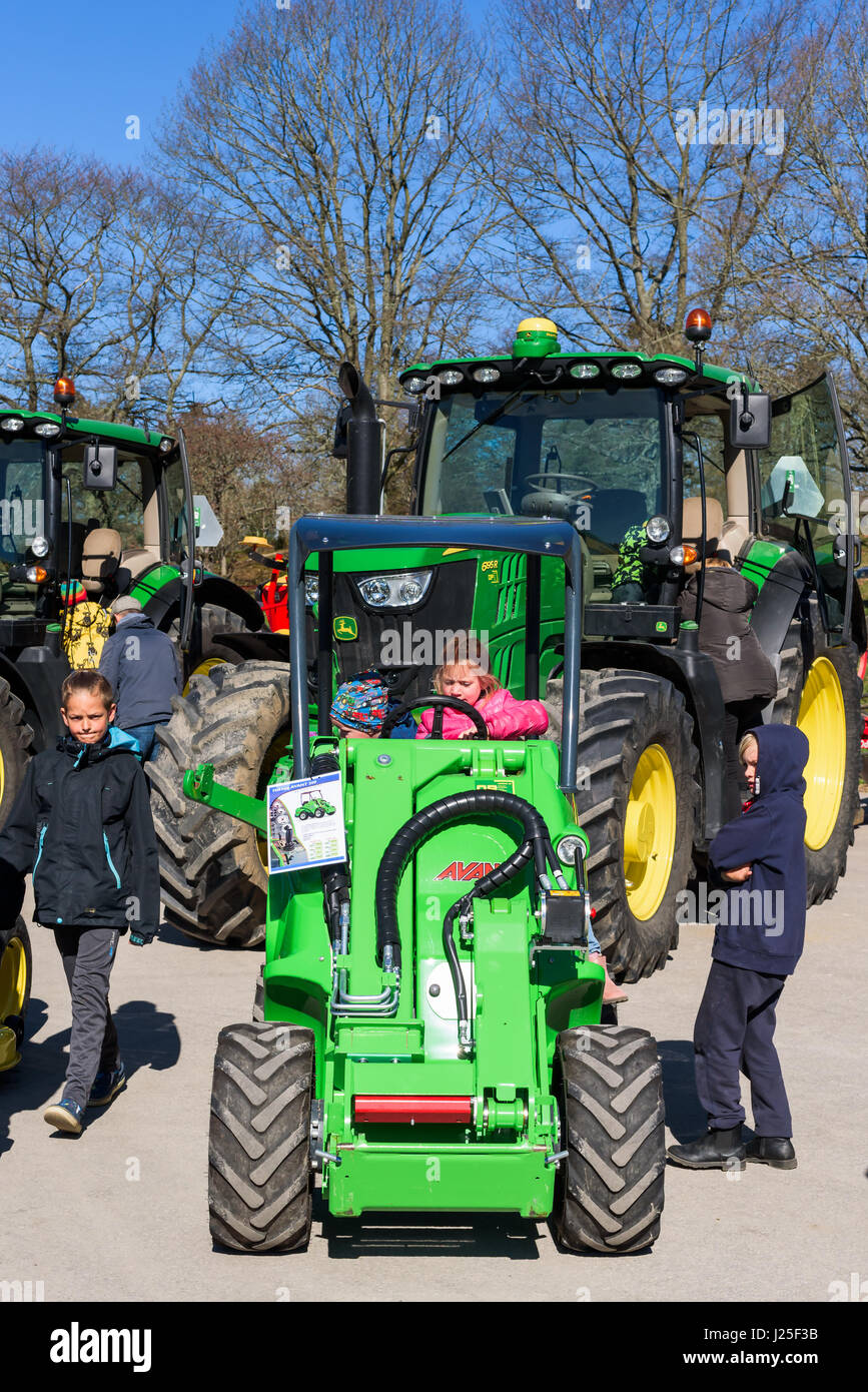 Brakne Hoby, Suecia - 22 de abril de 2017: Documental de los pequeños agricultores de público del día. Las familias que asisten a la exposición de tractores John Deere. Niños jugando Foto de stock
