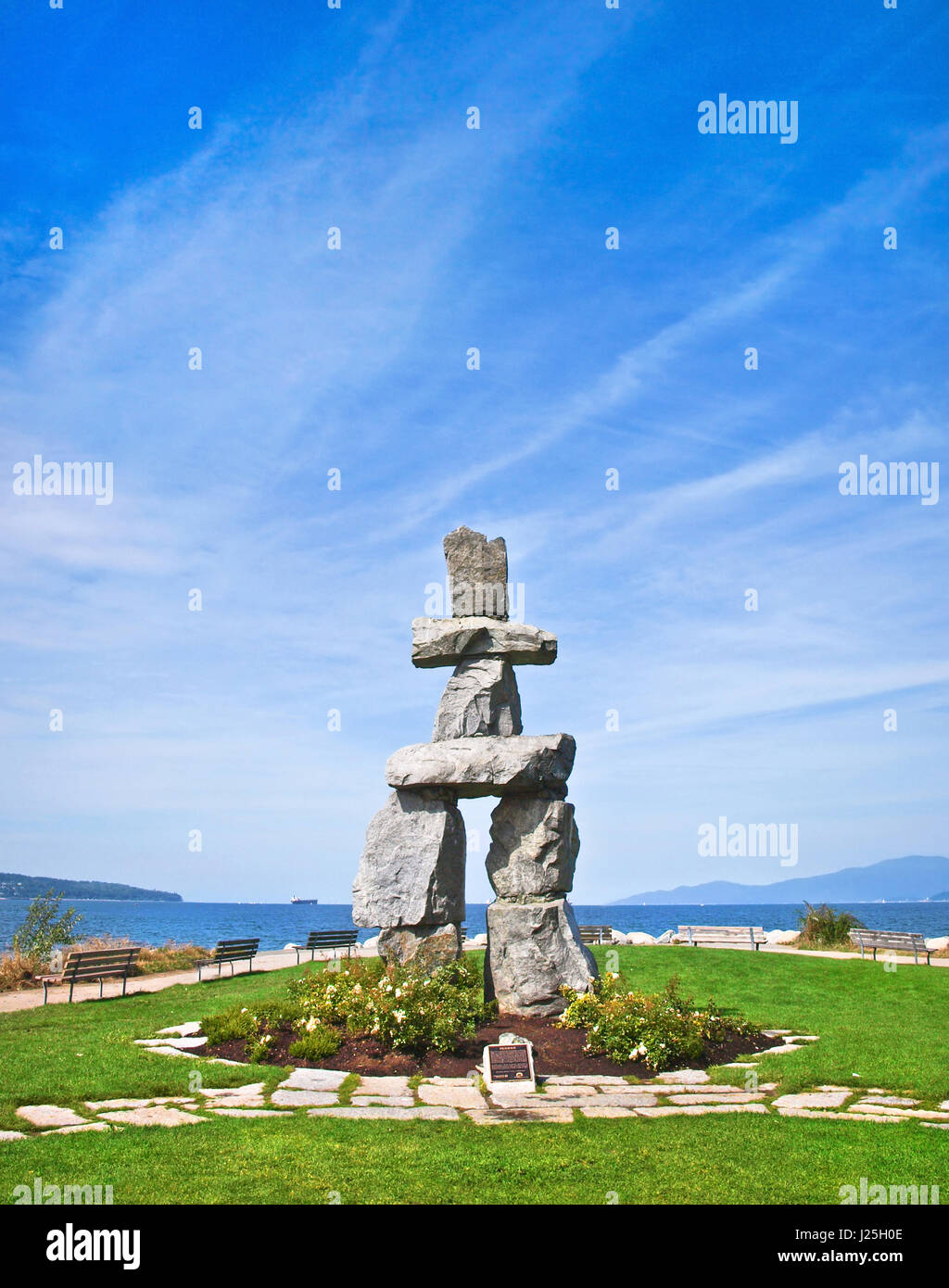 Inukshuk, símbolo de los juegos olímpicos de invierno del año 2010, con el cielo azul en English Bay en Vancouver, British Columbia, Canadá Foto de stock