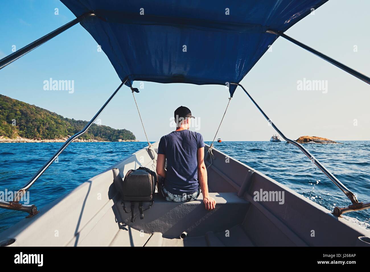 Aventura en el mar. Joven viajar por lancha. Foto de stock