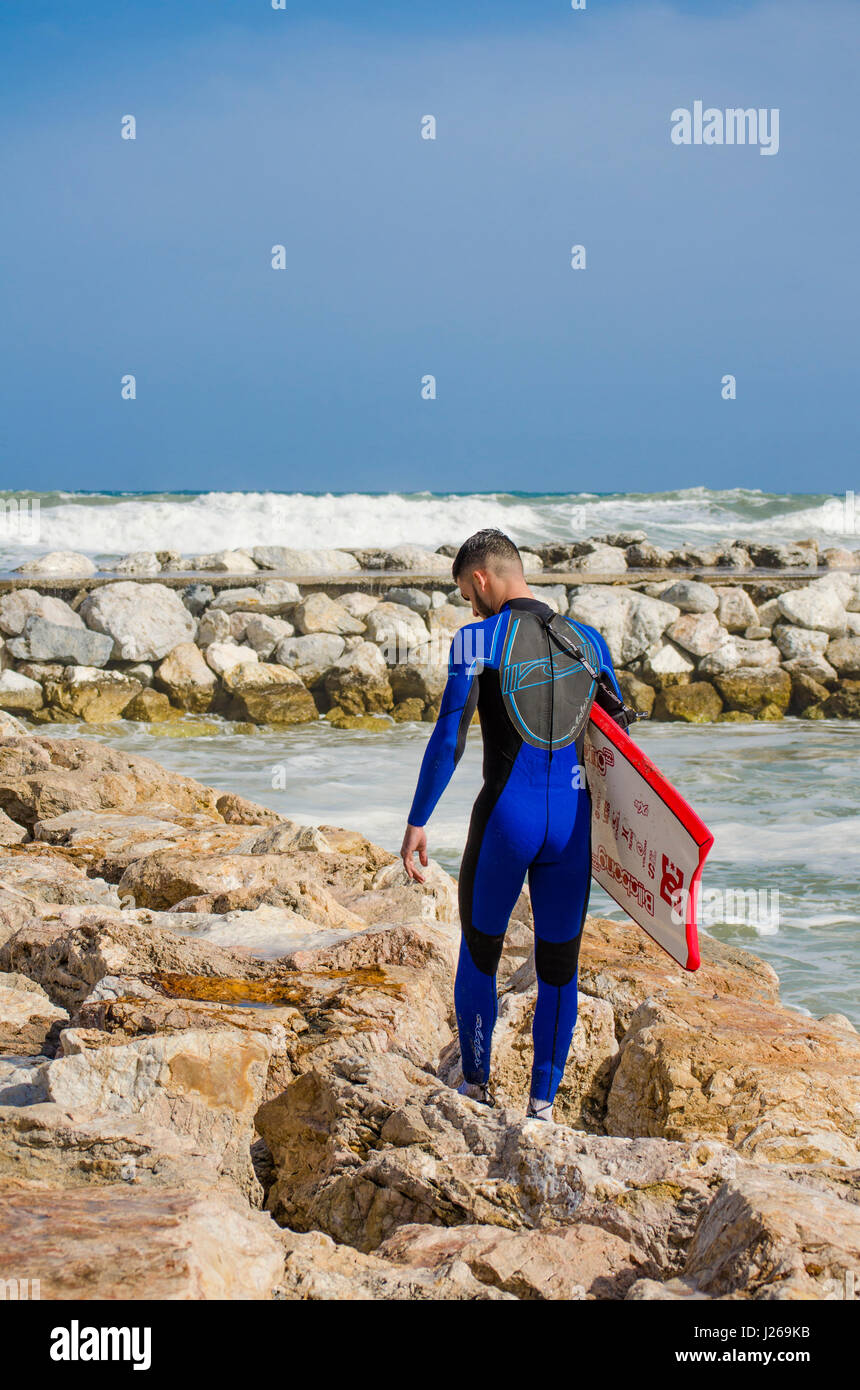 Joven con el bodyboard bodyboard, caminando en el muelle del surf