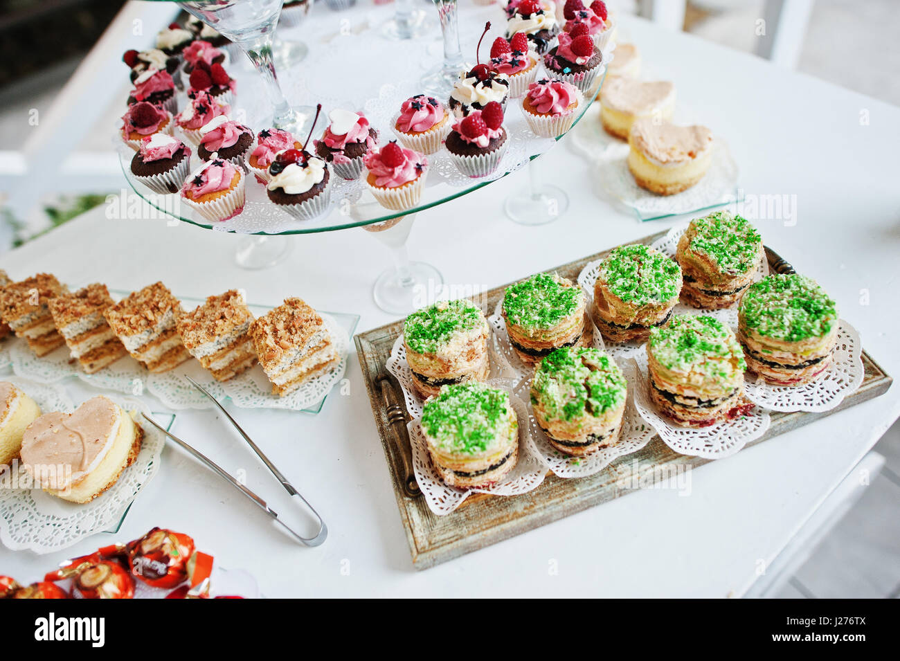 Catering de mesa con diferentes tortas y pastelitos en la recepción de
