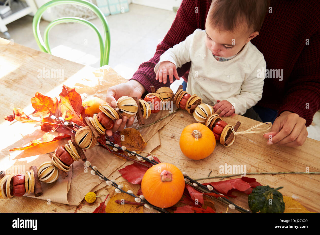 Madre e hija haciendo otoño decoración en casa Foto de stock