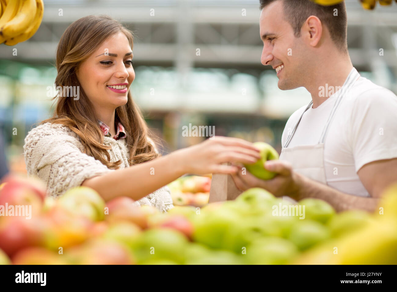 Sonrisa y vendedor con Apple Foto de stock