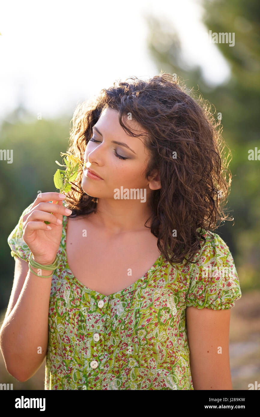 Mujer respirar el olor de una planta Foto de stock