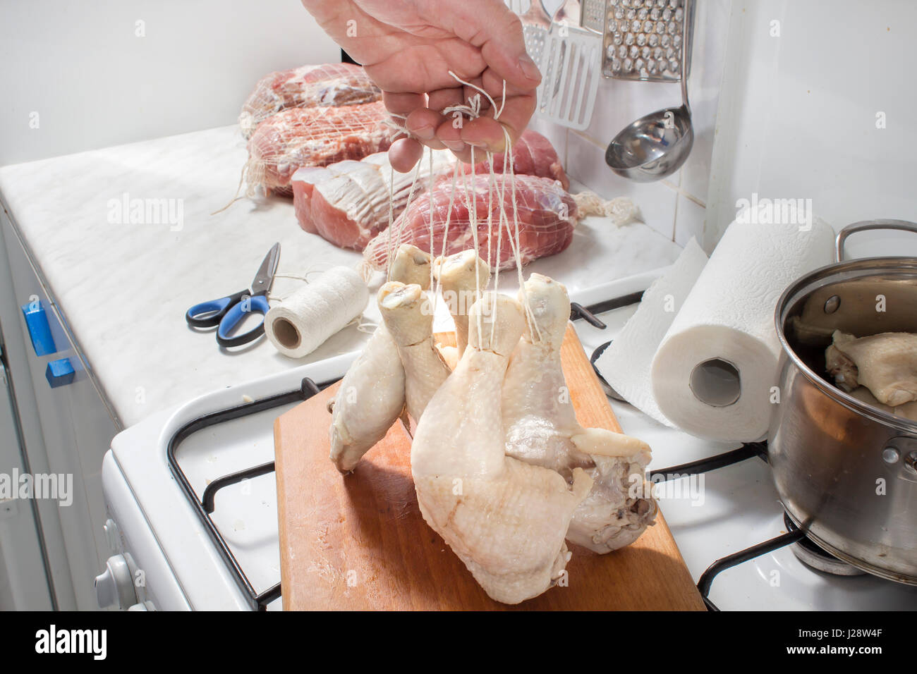 Preparación de la carne de pollo para fumadores. El embalaje de la carne en una salchicha net. Carne preparada para fumar Foto de stock