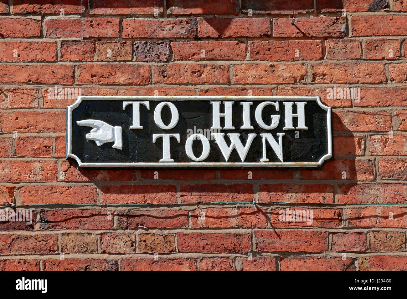 Hierro fundido a alta ciudad signo en la pared de ladrillo rojo en Cartway, Bridgnorth, Shropshire, Inglaterra, Reino Unido. Foto de stock