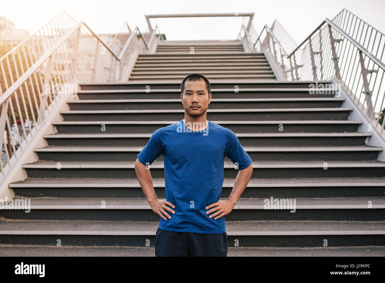 Athletic hombre asiático obteniendo enfocado para ejecutar urbana Foto de stock