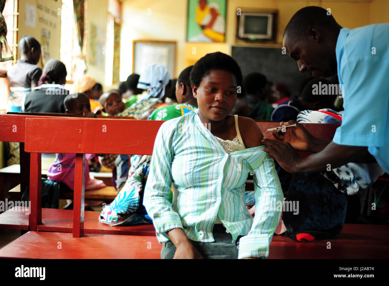 Malawi, Región Norte, Rumphi, ayudante de la vigilancia de la Salud (HSA) discoteca Kayire dando la vacuna a una madre Foto de stock
