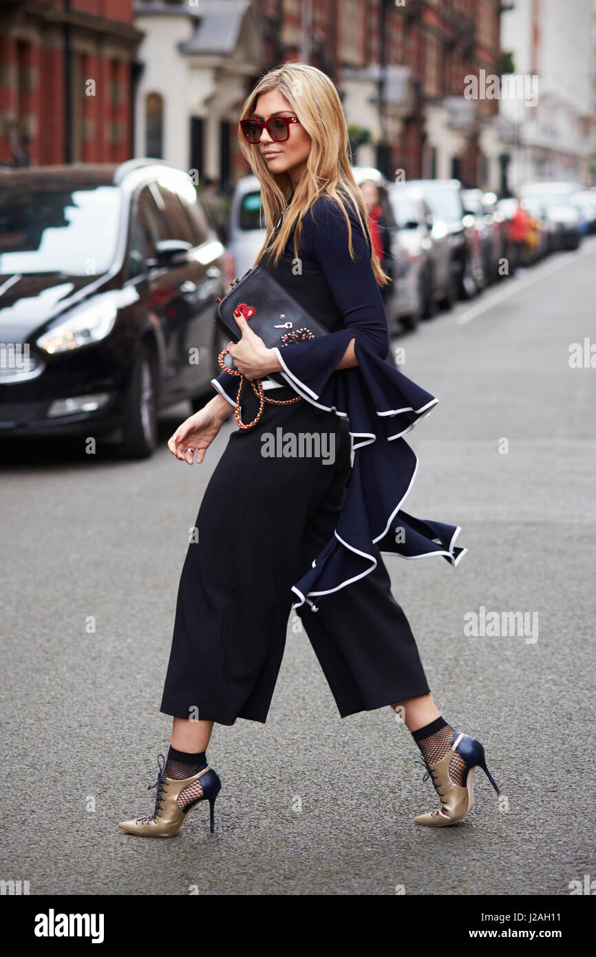 Londres - Febrero, 2017: blogger de moda Natalia Georgala cruzando la calle, la Semana de la Moda de Londres, el día 4. Foto de stock