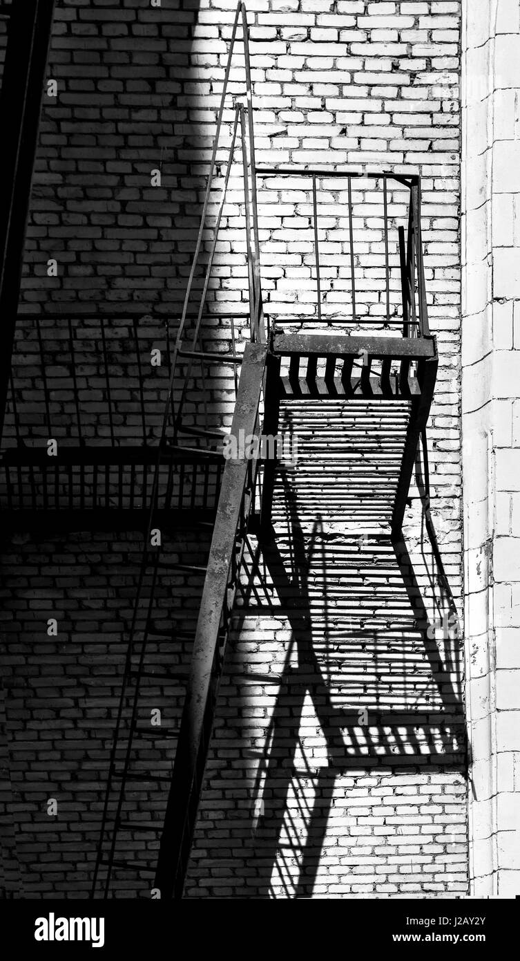 Elegante escalera de incendios en la pared en blanco y negro Foto de stock