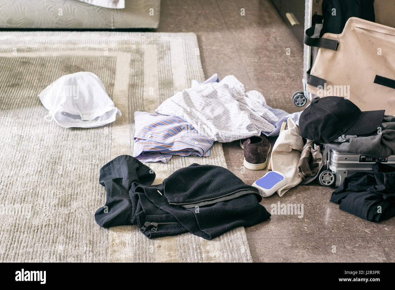 Maleta abierta y ropa esparcidos por el suelo, interior filtra closeup  Fotografía de stock - Alamy