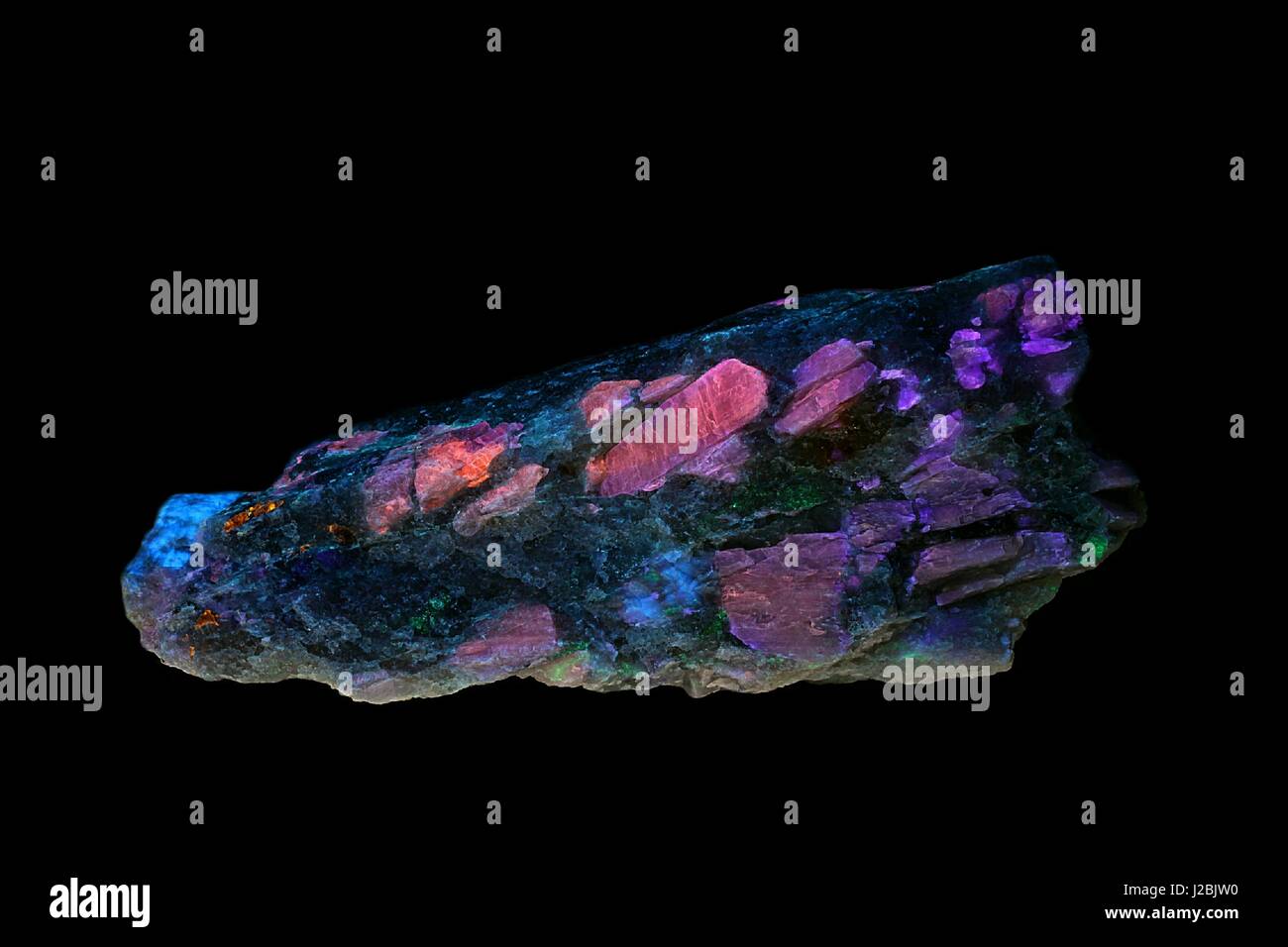 Minerales de litio spodumene mostrando fluorescencia en luz ultravioleta Foto de stock