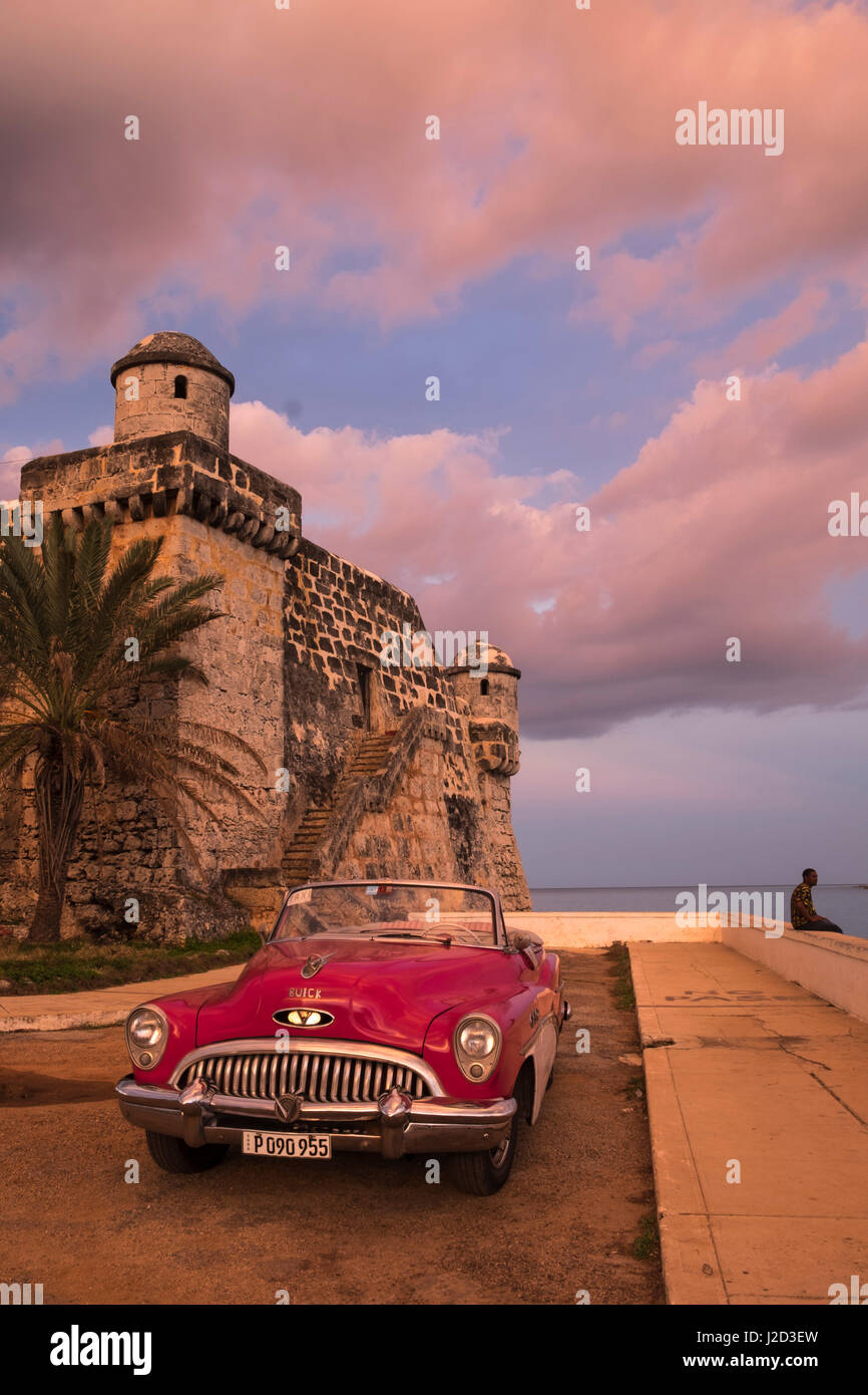 Cuba, Cojimar. Clásico americano coche aparcado delante de una fortaleza. Foto de stock