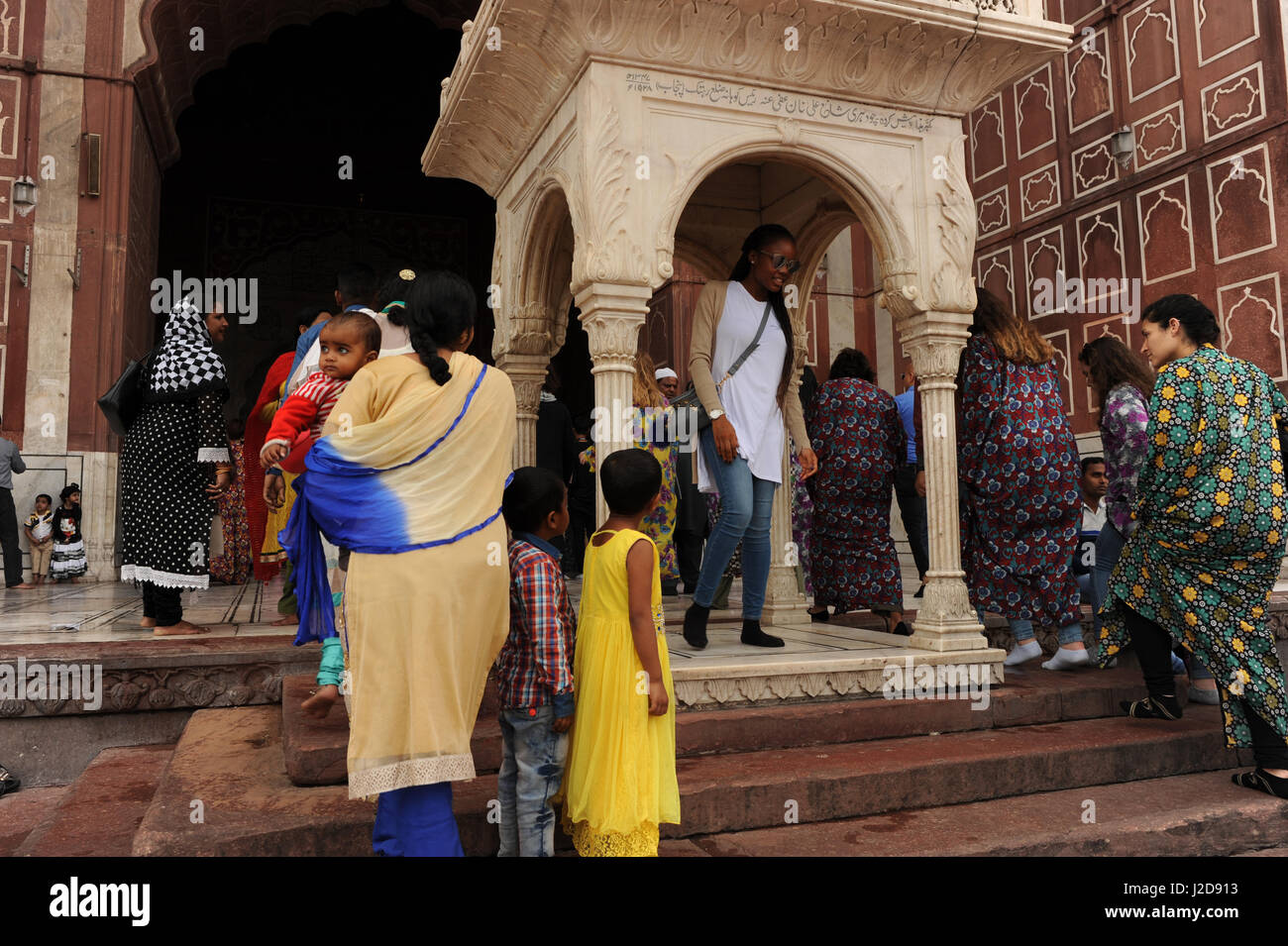 Los turistas posan para fotografías en la Jama Masjid mezquita de Delhi, India Foto de stock