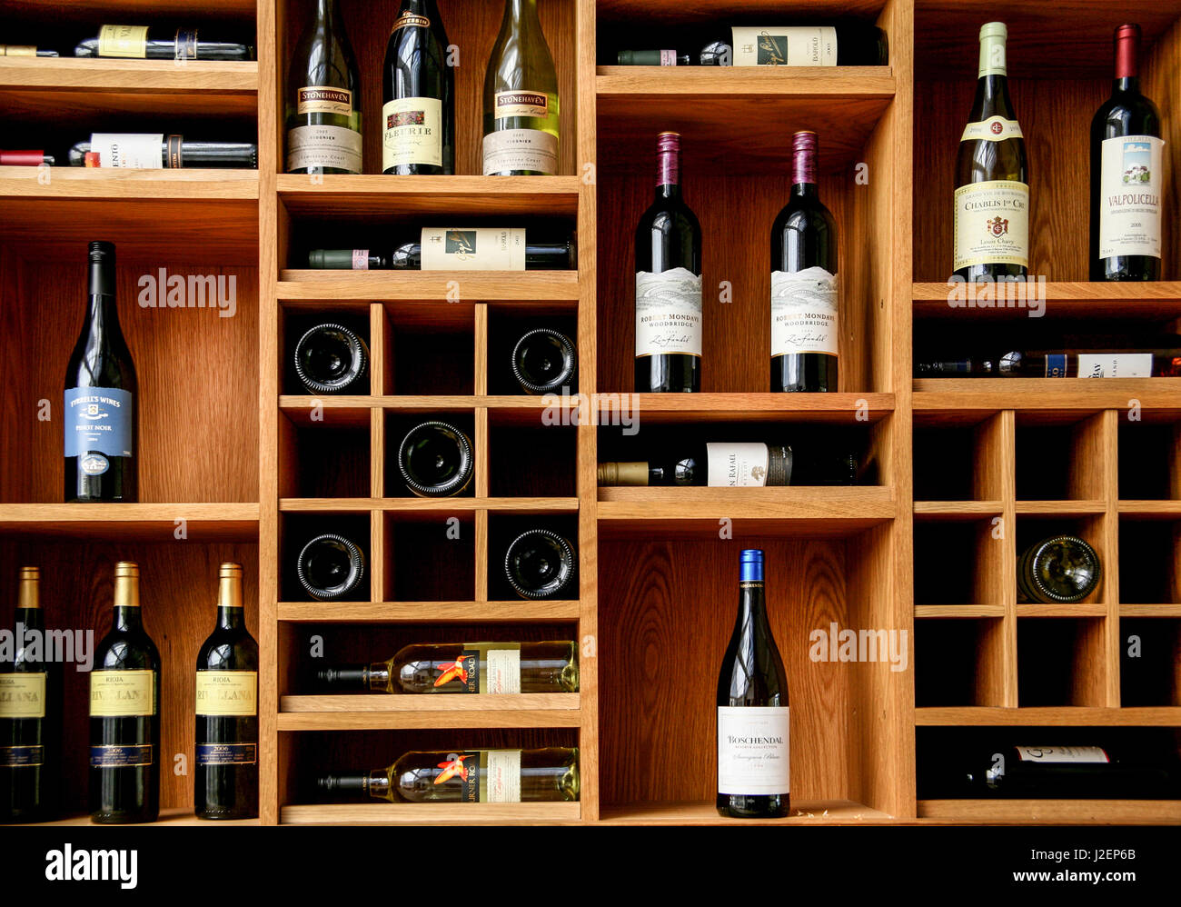 Las botellas de vino rojo y blanco en la pantalla en un bar en estantes de  madera Fotografía de stock - Alamy