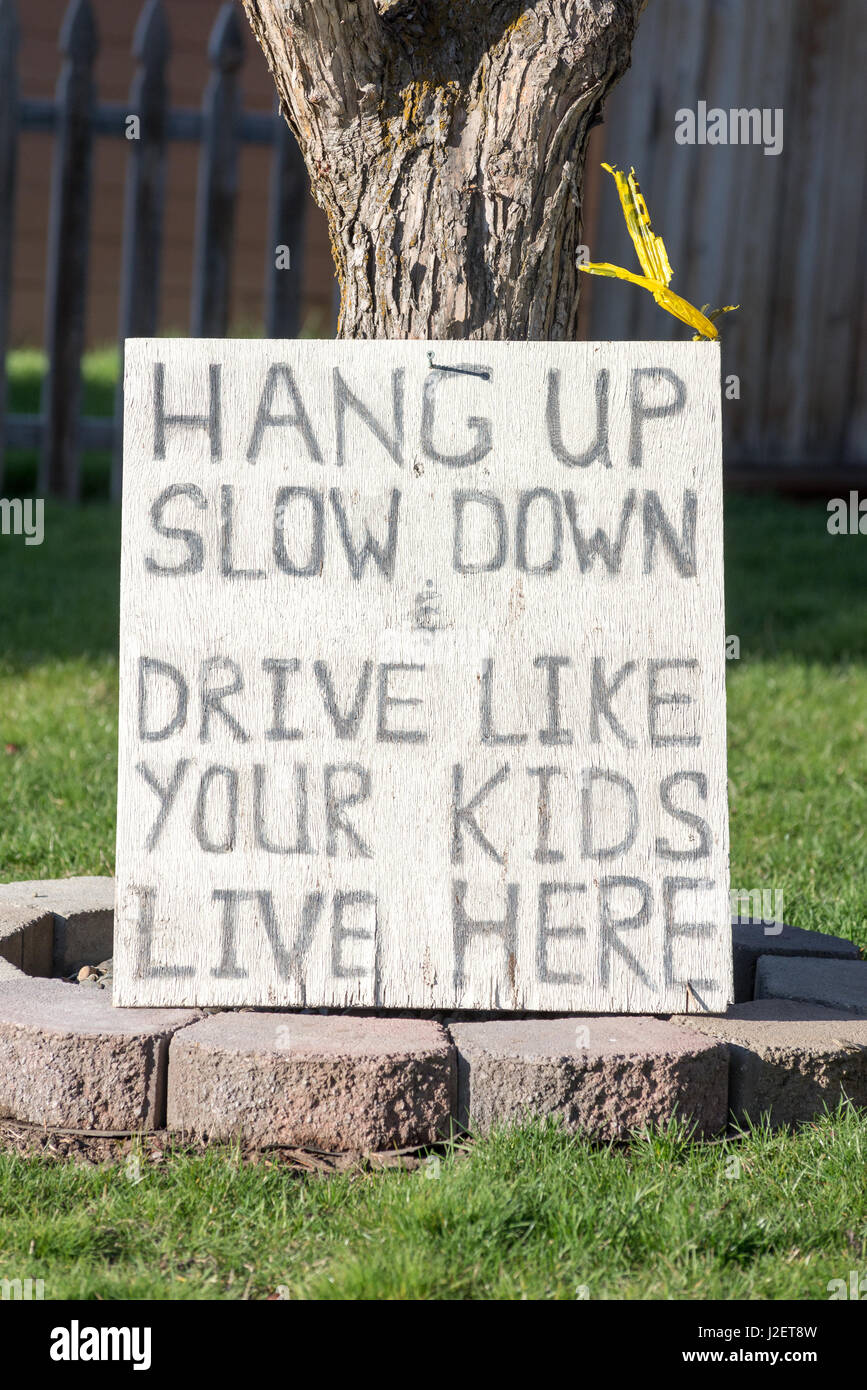 Signo delante de una casa que advierta a los conductores a no conducir mientras hablando en sus teléfonos, Enterprise, Oregon. Foto de stock