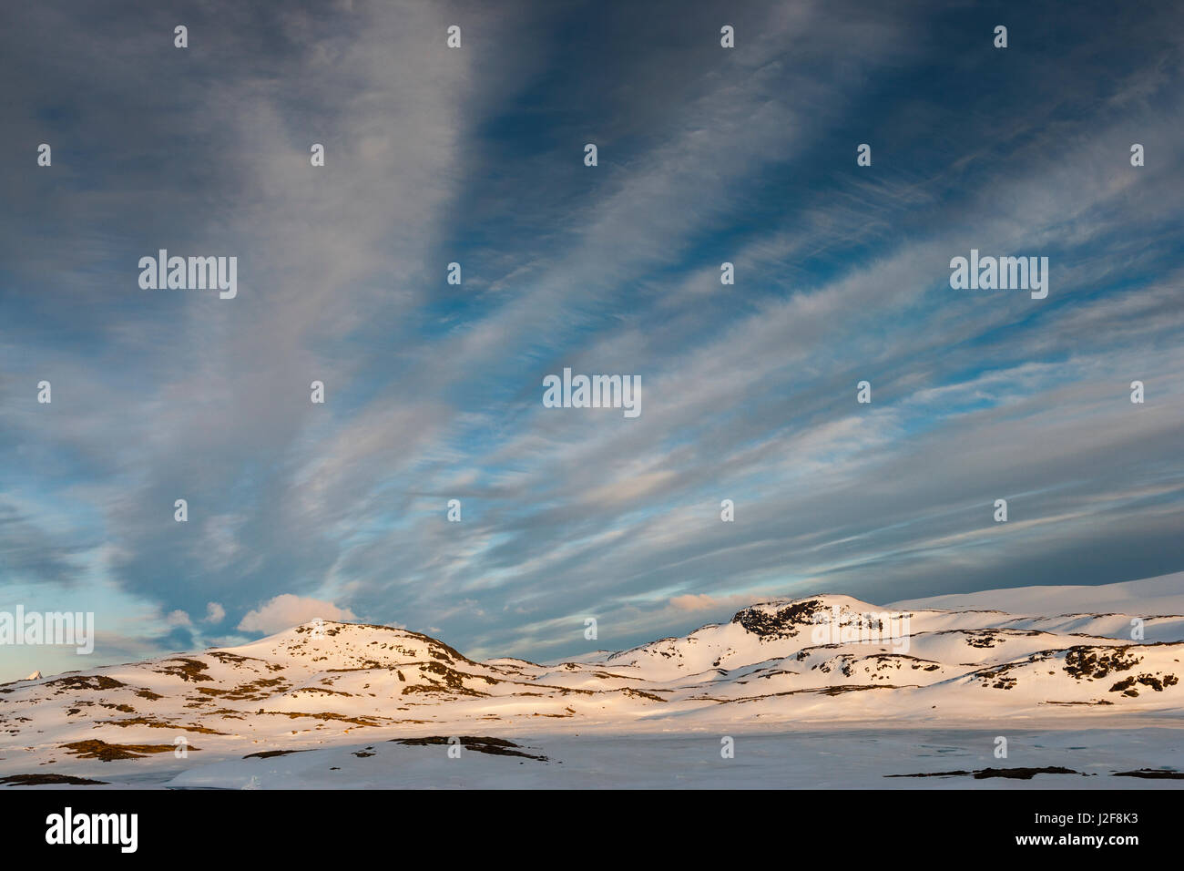Las montañas de Jotunheimen en luz del atardecer bajo un cielo con nubes cirrus Foto de stock