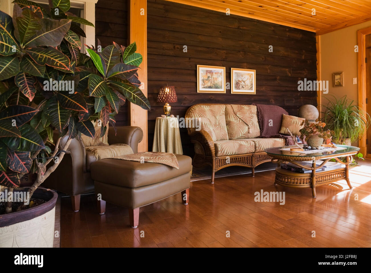 Silla de cuero marrón con otomana y sofá de mimbre en el solarium extensión  conectada a una antigua casa residencial de estilo casa de campo 1877  Fotografía de stock - Alamy