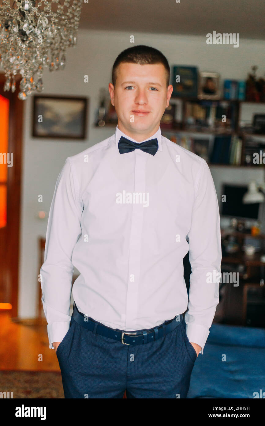 Retrato de elegante moda joven hombre de camisa blanca y pajarita  Fotografía de stock - Alamy