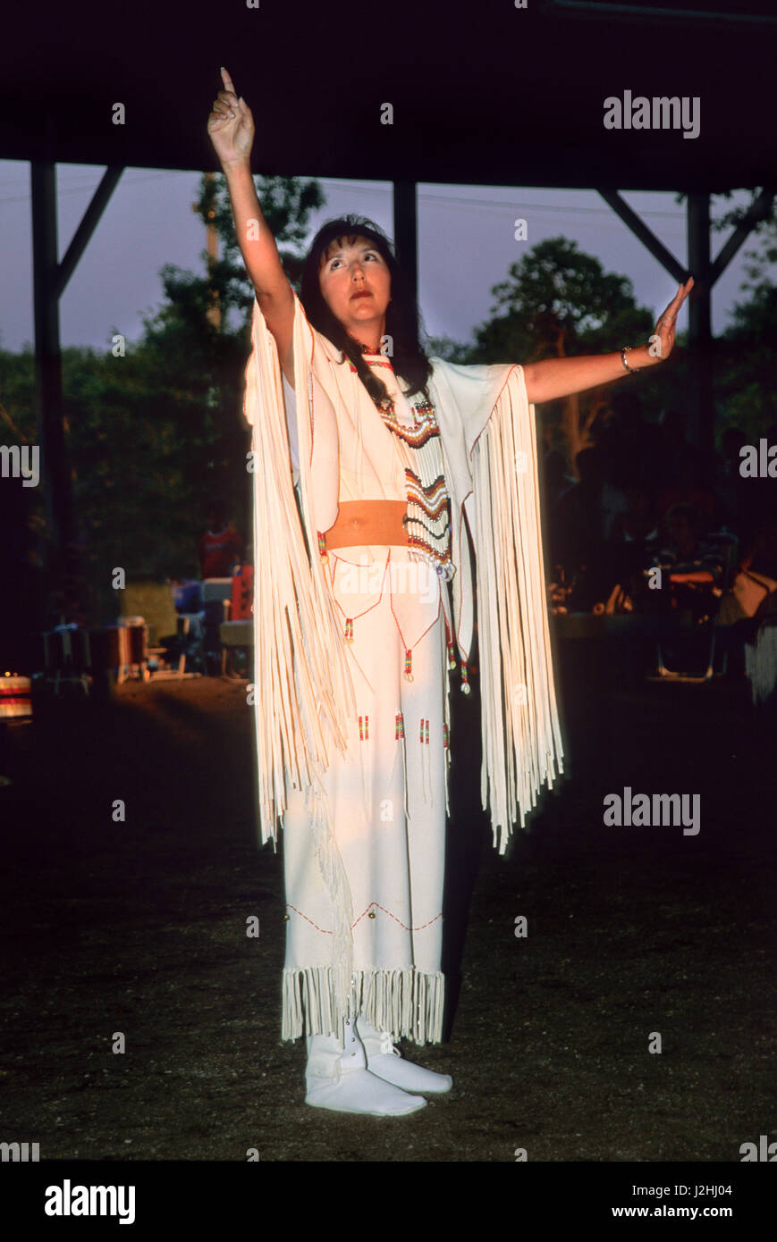 Mujer vestida de cerebro tradicional curtidas vestido con flecos demuestra el lenguaje de señas americano nativo durante una oración de apertura en el Miami anual Pow Wow Potawatomi, Oklahoma Foto de stock
