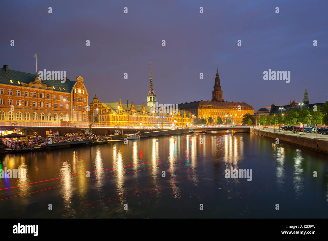 Vista nocturna de Christiansborg Palace y el edificio de la Bolsa a través del canal en Copenhague. Foto de stock