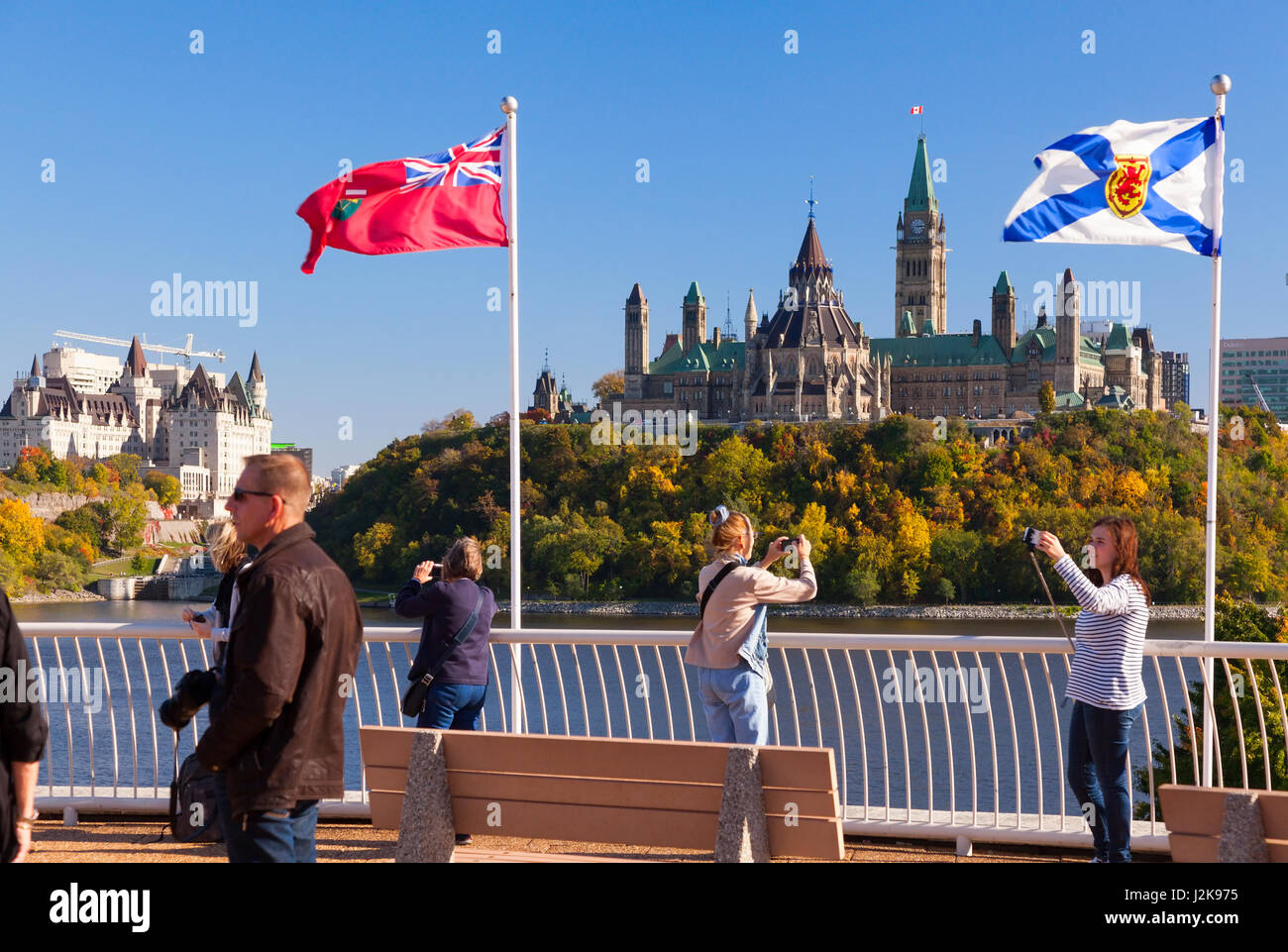 La Colina del Parlamento en Ottawa, Ontario, con turistas en primer plano tomando fotografías como se ve desde el casco, Gatineau, Quebec, Canadá. Foto de stock