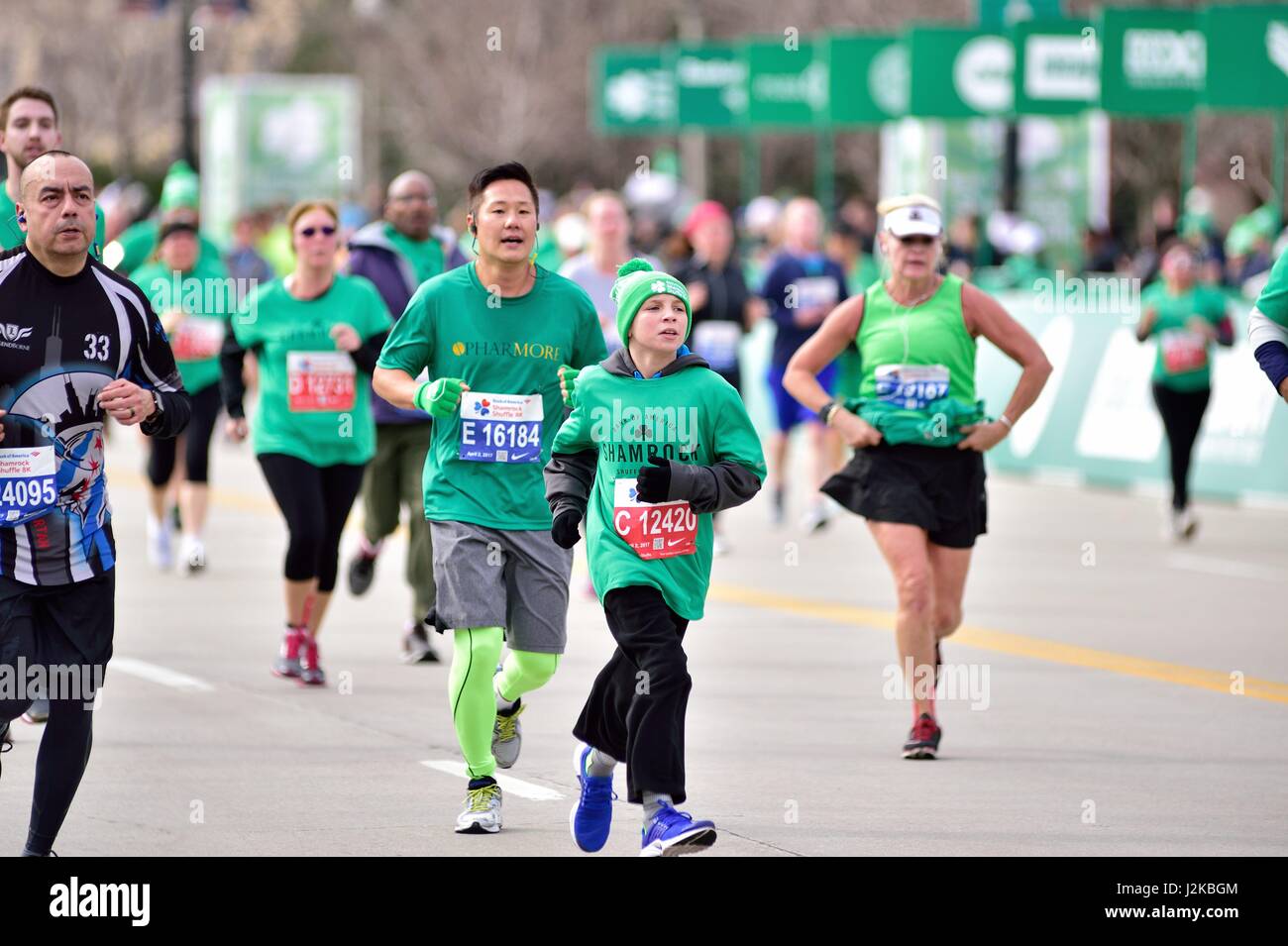 Un grupo de corredores que incluye a un hijo cuando se acercan a la línea  de meta en el 2017 Shamrock Shuffle 8K de la Raza en Chicago, Illinois,  Estados Unidos Fotografía