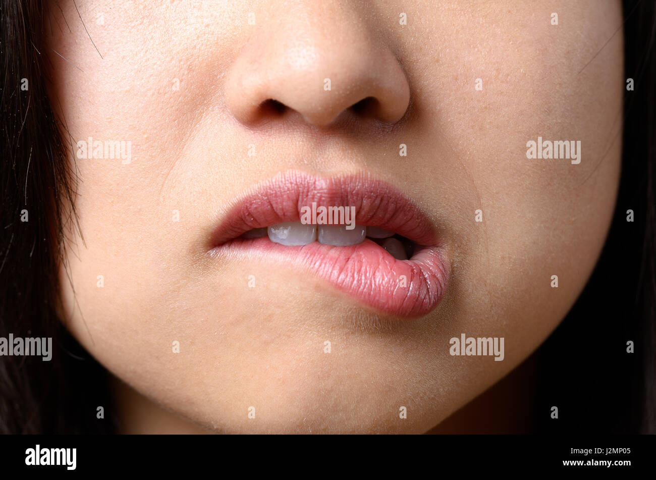 Pensativo mujer muerde su labio con sus dientes como ella reflexiona sobre  un problema o intenta recordar Fotografía de stock - Alamy