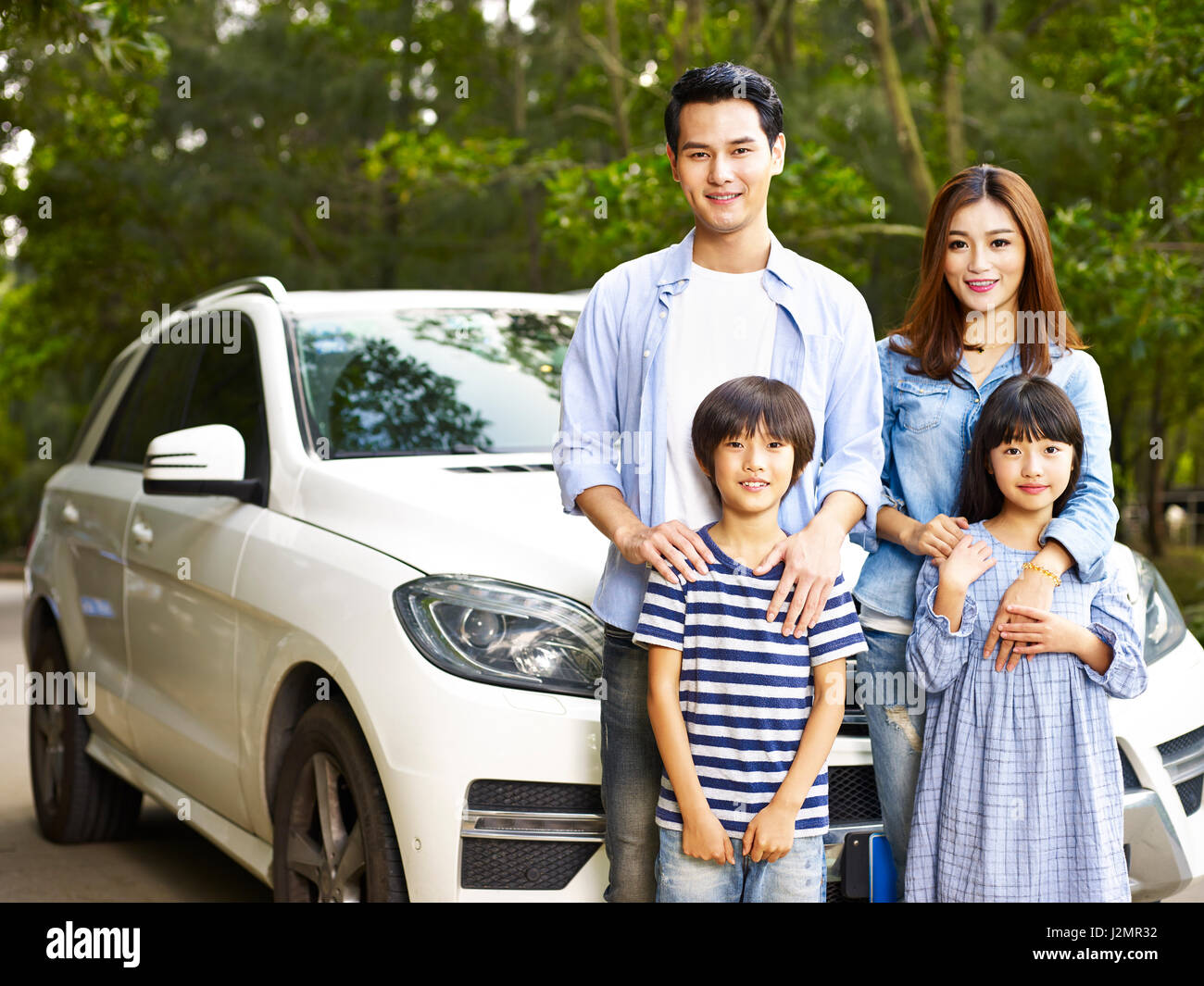 Familia con dos niños asiáticos tomando una fotografía durante los viajes en coche. Foto de stock